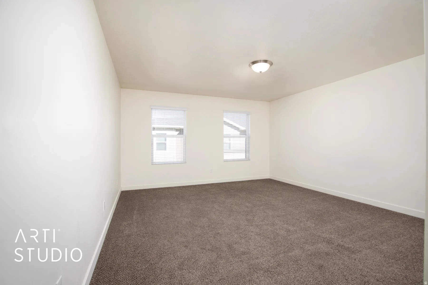Unfurnished room with dark colored carpet and baseboards