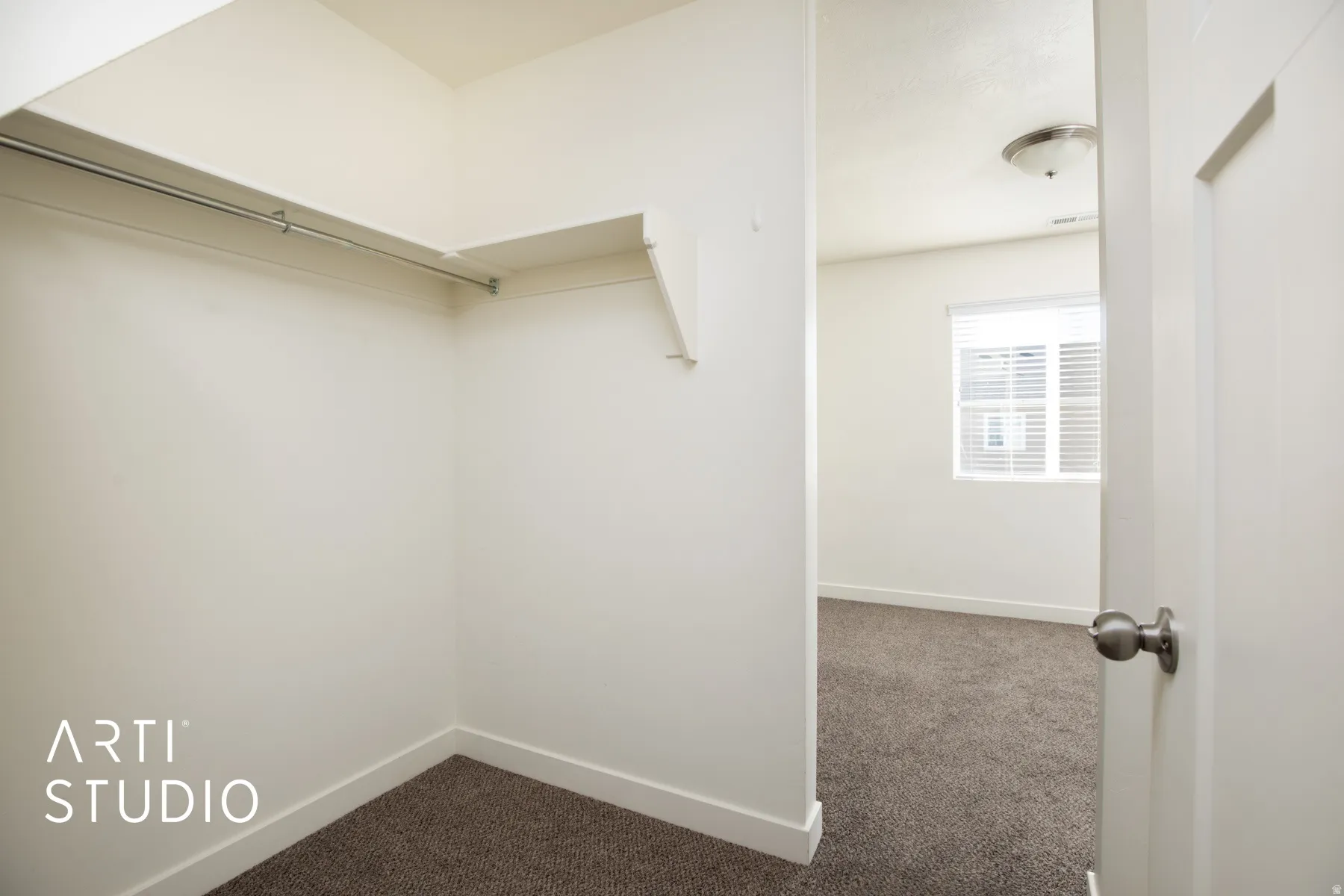 Walk in closet with carpet connected to upstairs bedroom and bathroom.