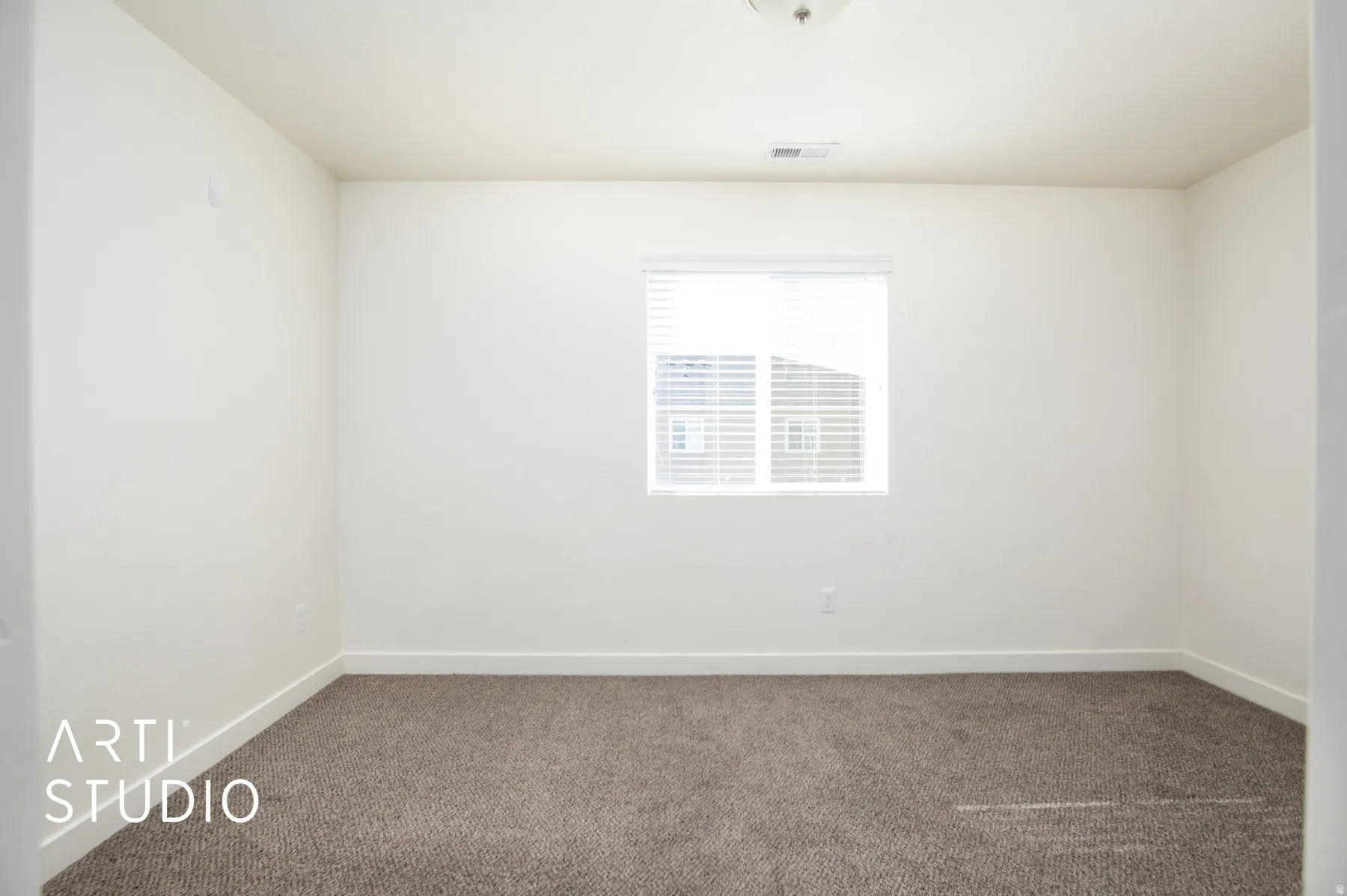 Carpeted spare room featuring baseboards