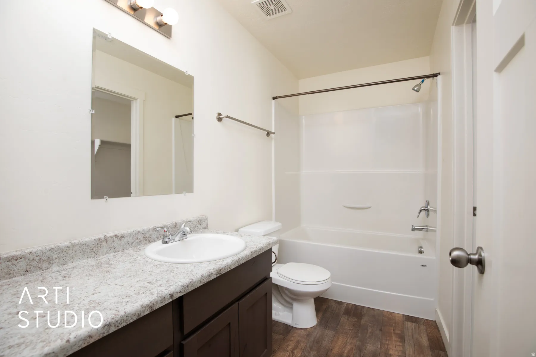 Full bathroom with vanity, dark wood finished floors, and shower / bath combination