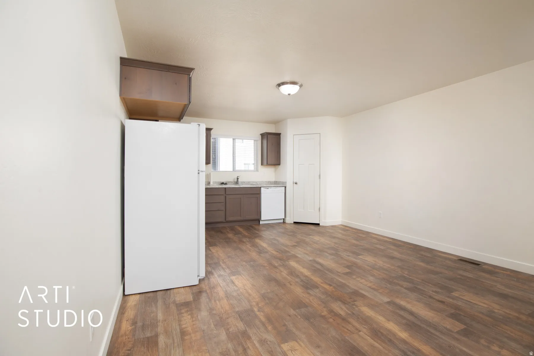 Kitchen with white appliances, dark wood-type flooring, and light countertops