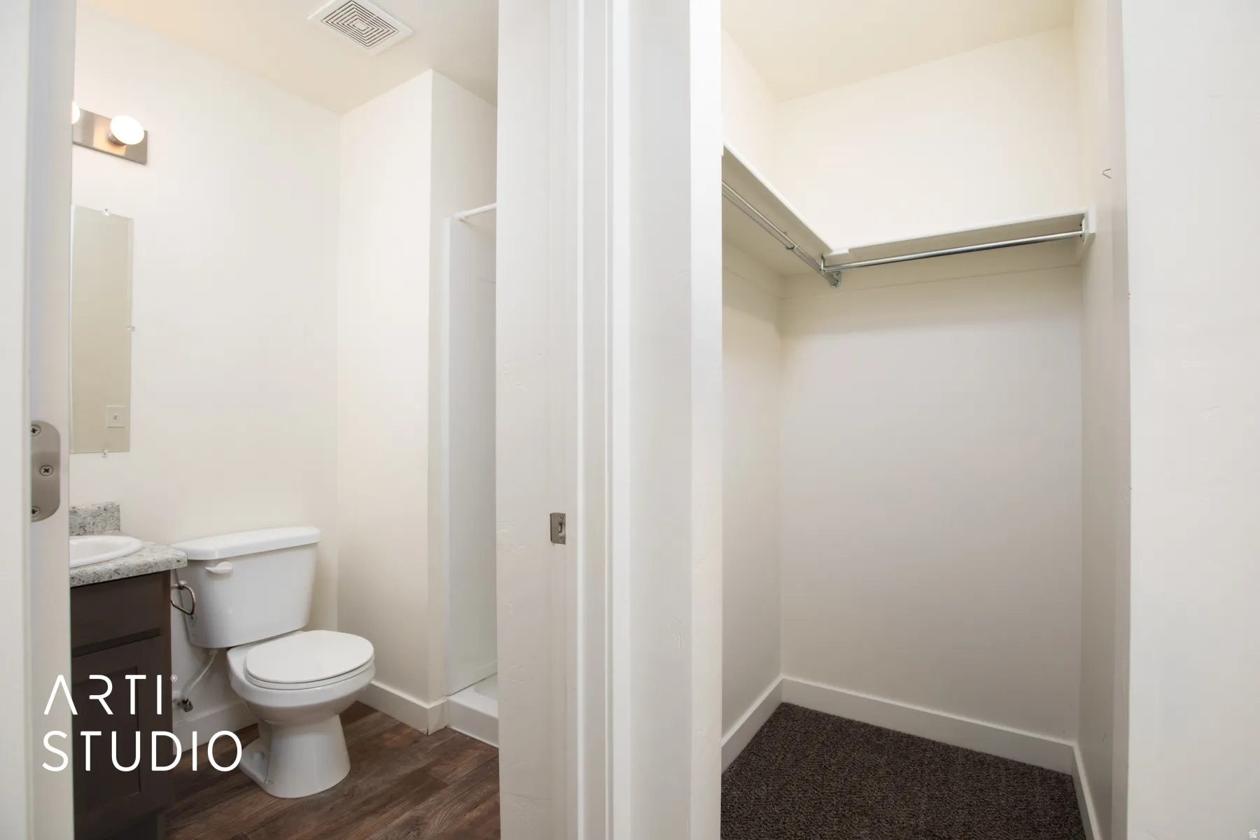 Primary bath and closet. Full bathroom featuring a spacious closet, vanity, a shower, and dark wood-style floors
