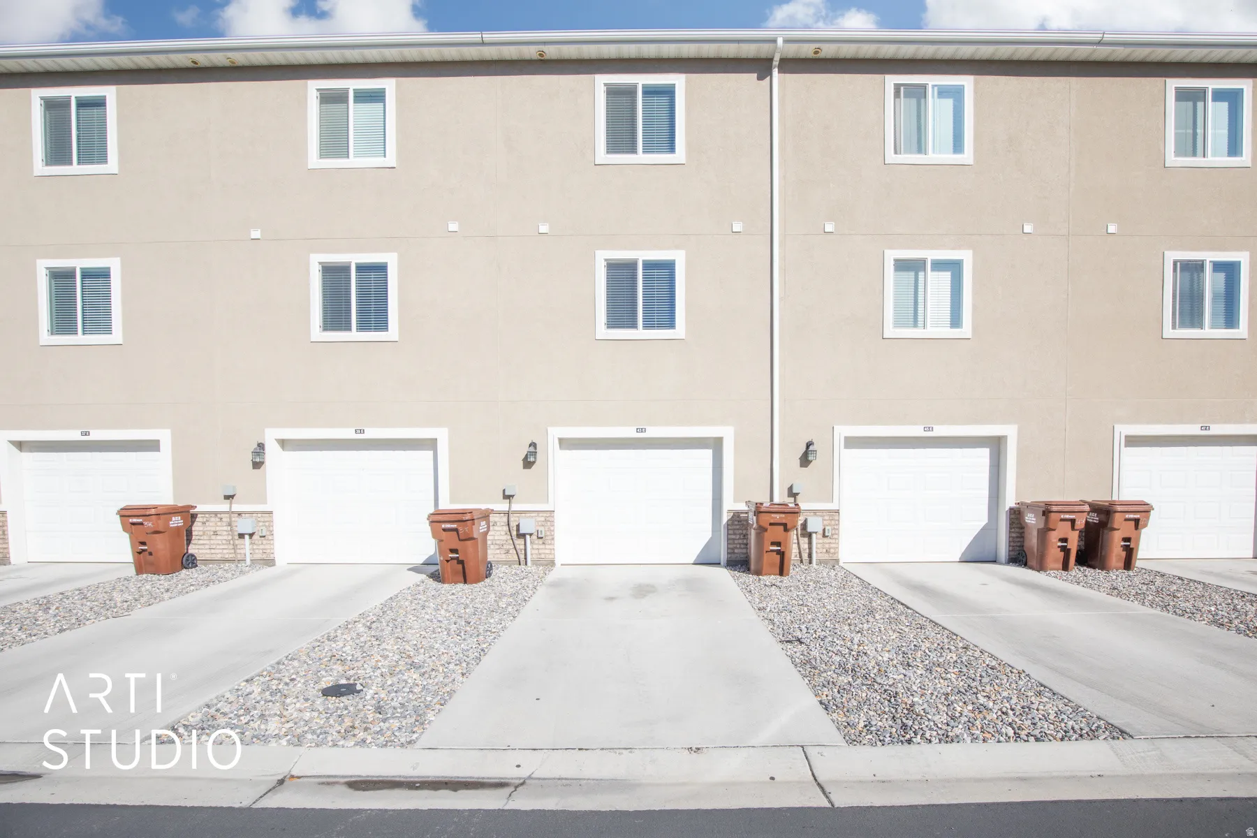 View of property exterior featuring concrete driveway, an attached garage, and stucco siding