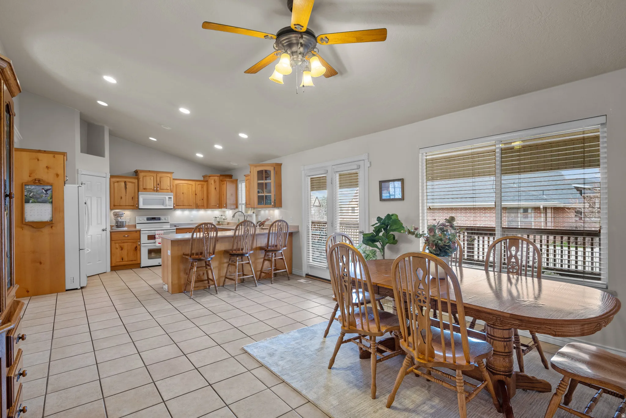 Dining space with recessed lighting, a ceiling fan, light tile patterned floors, and vaulted ceiling
