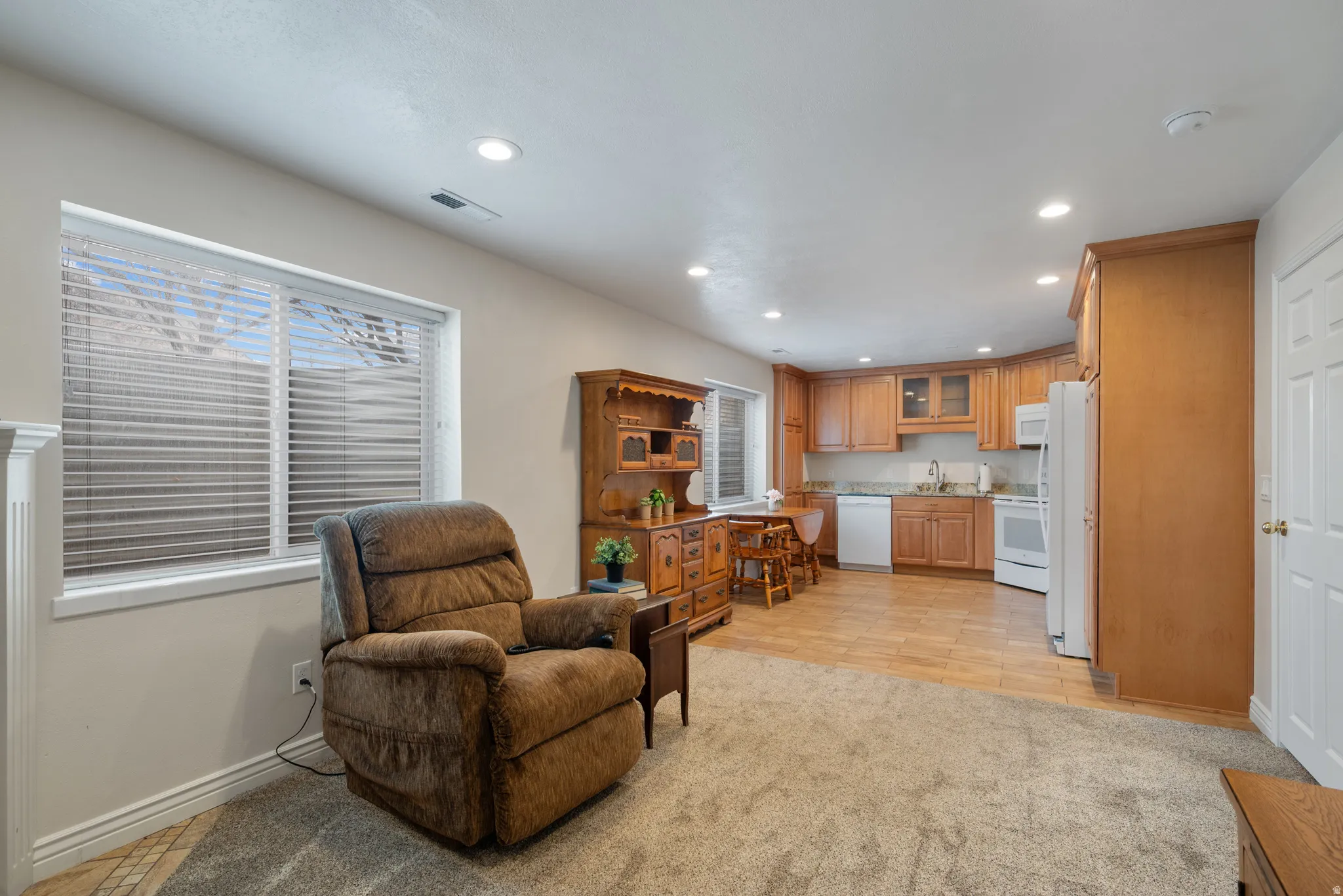 Sitting room  with full kitchen featuring recessed lighting and light carpet