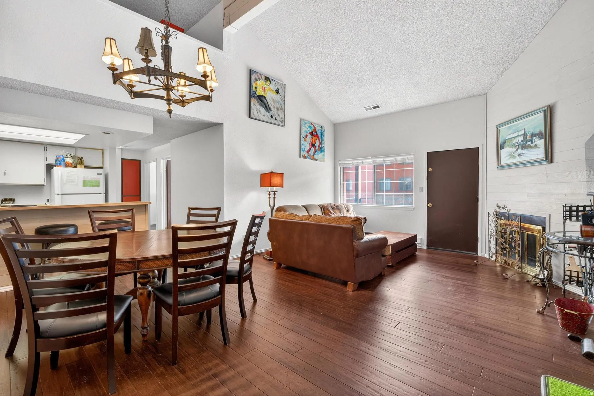 Dining space with hardwood / wood-style flooring, suspended lighting, and a glass covered fireplace