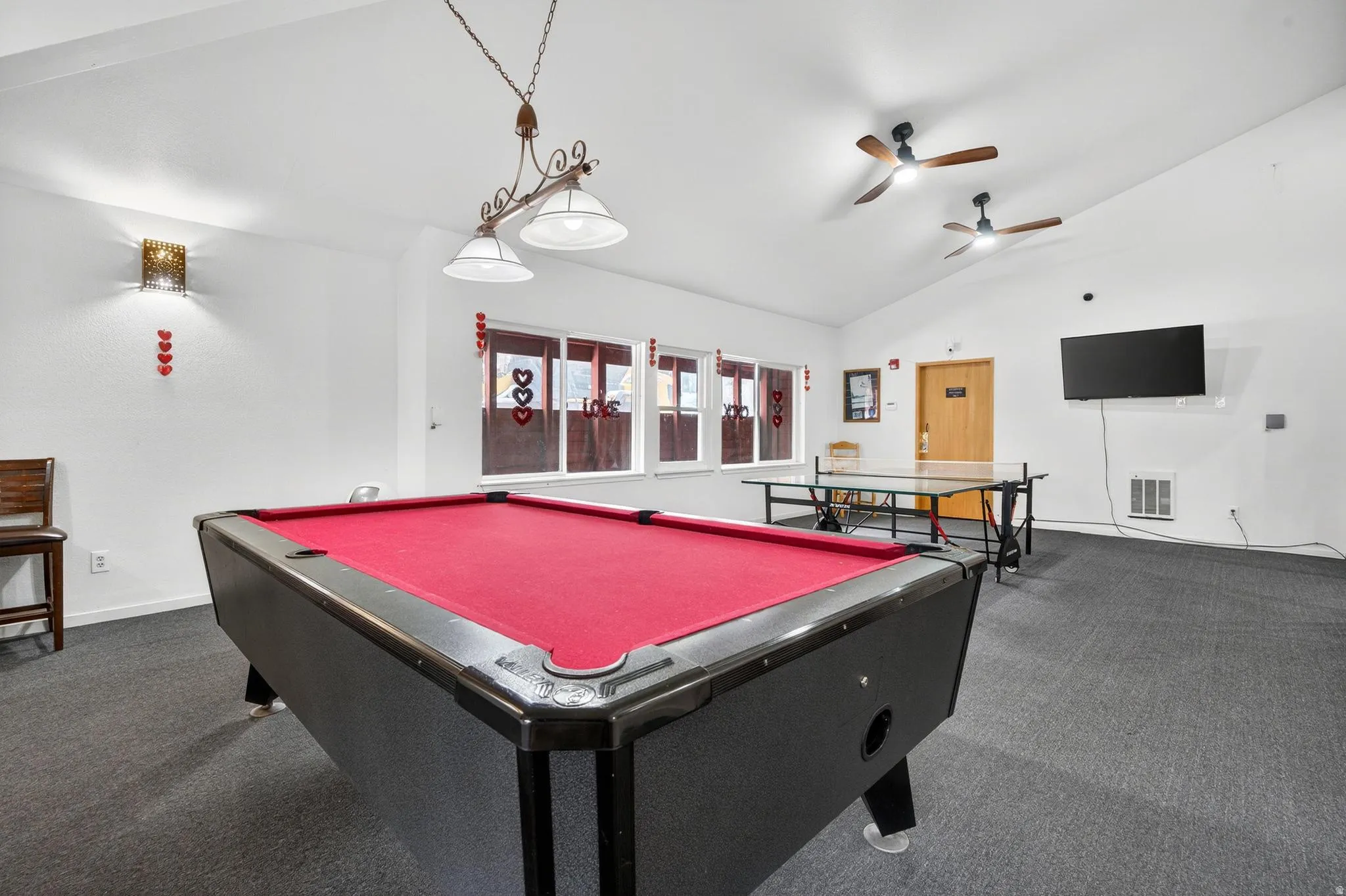 Recreation room with dark carpet, vaulted ceiling, billiards table, and ceiling fan