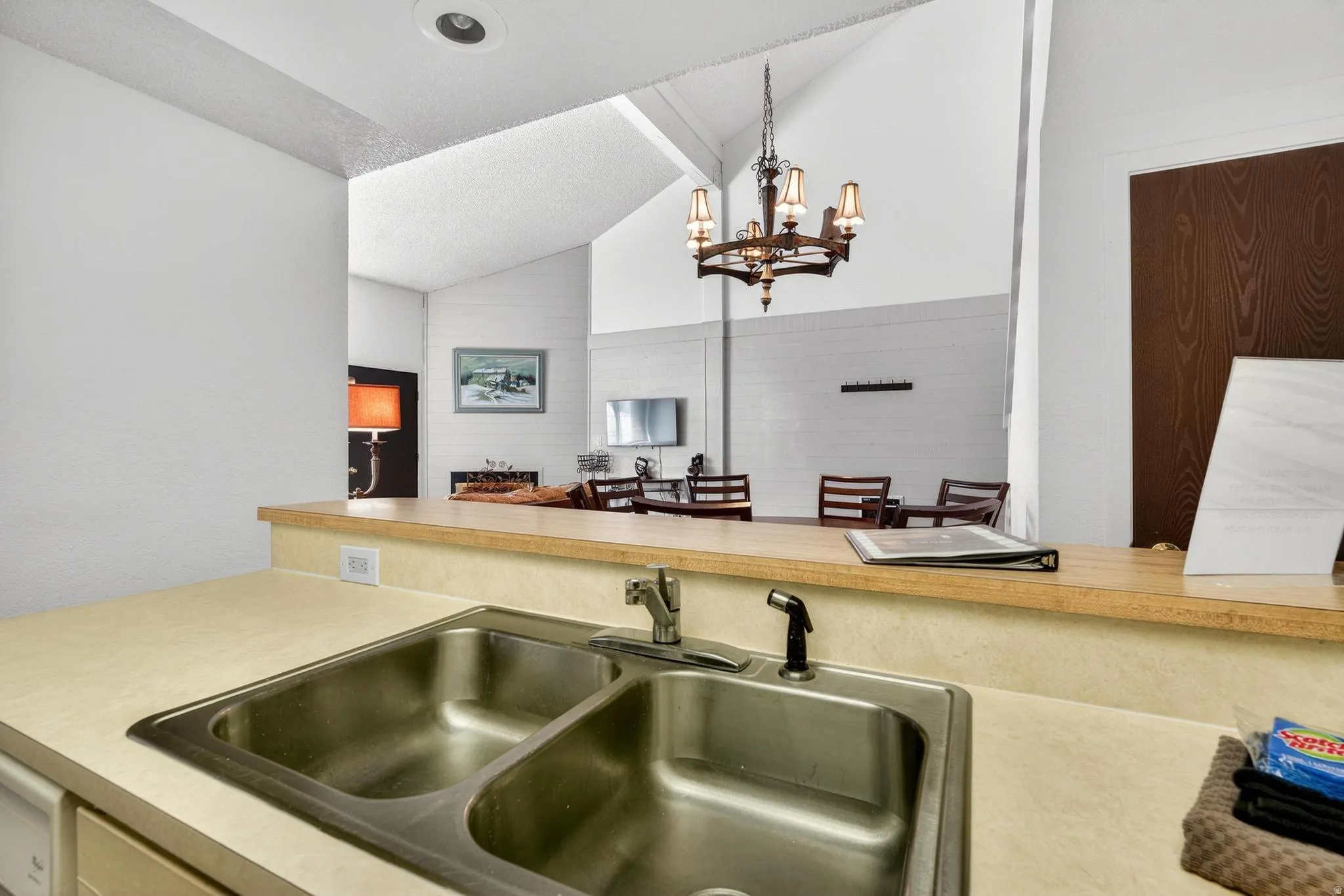 Kitchen with lofted ceiling, light countertops, and suspended lighting