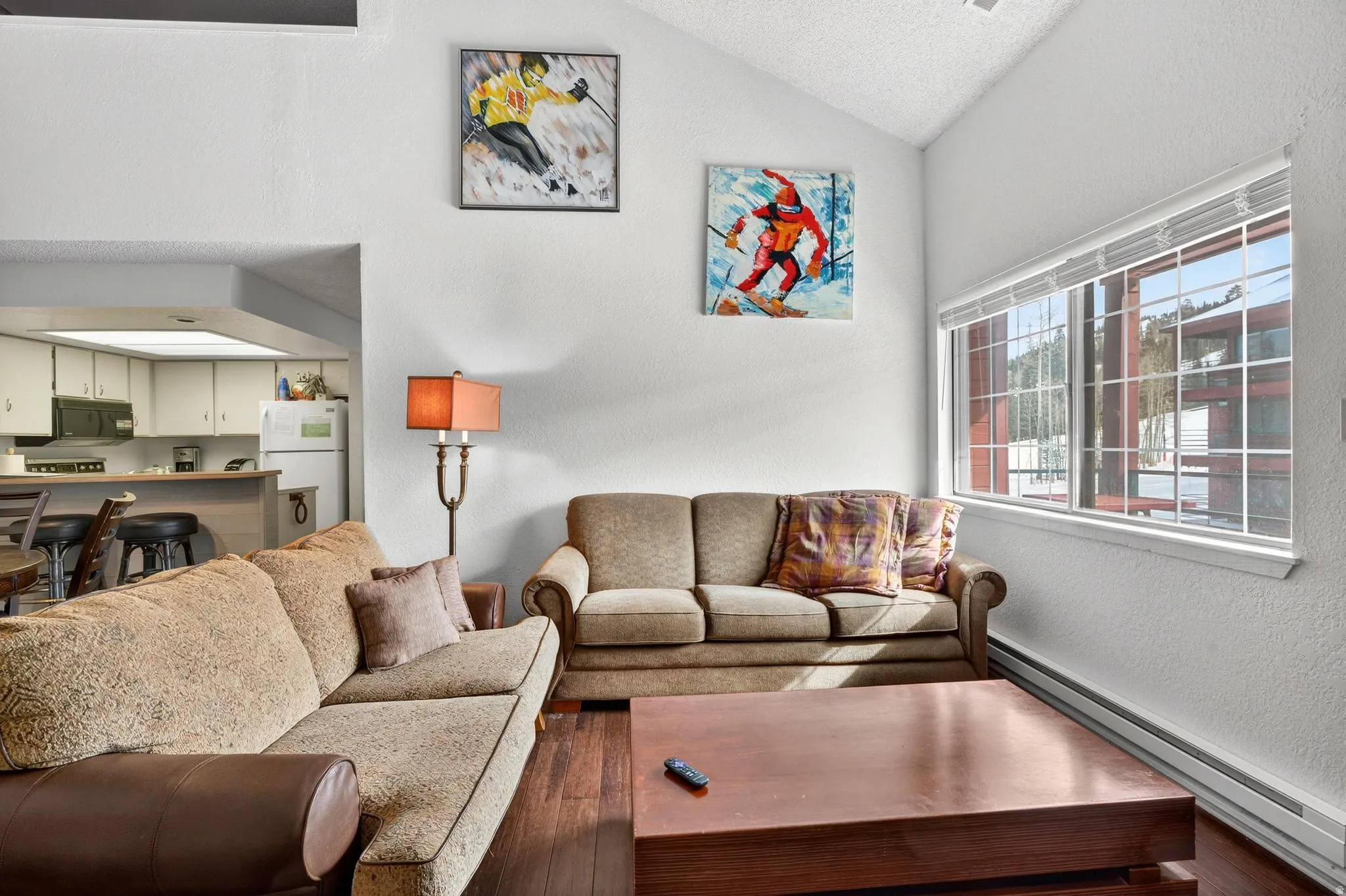 Living area with a textured wall and a baseboard radiator