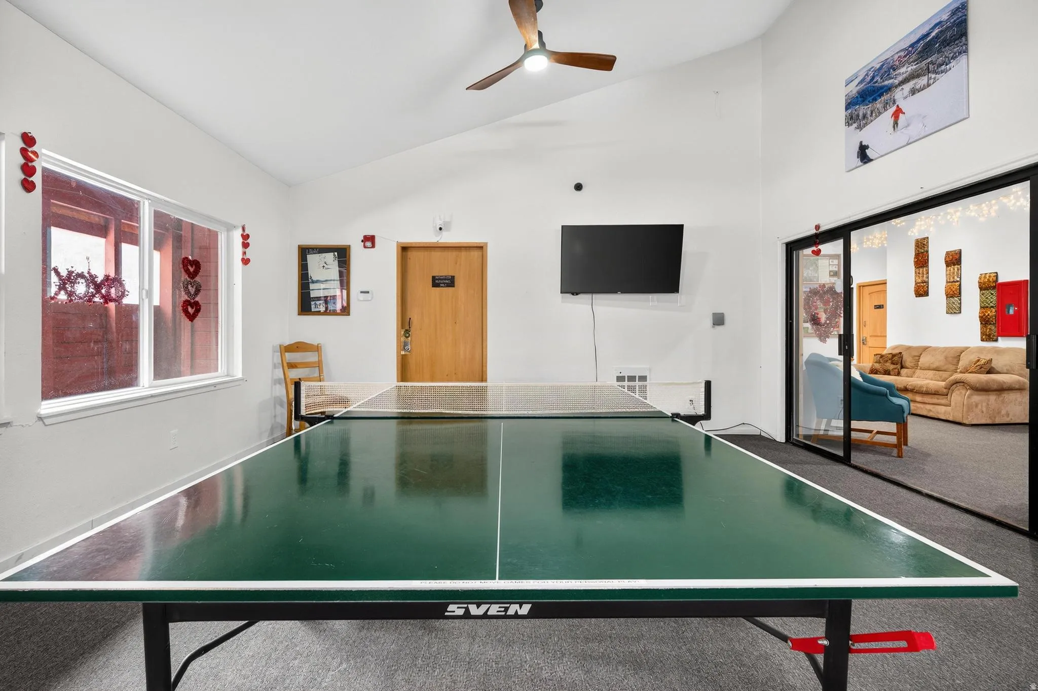 Recreation room featuring ceiling fan and lofted ceiling