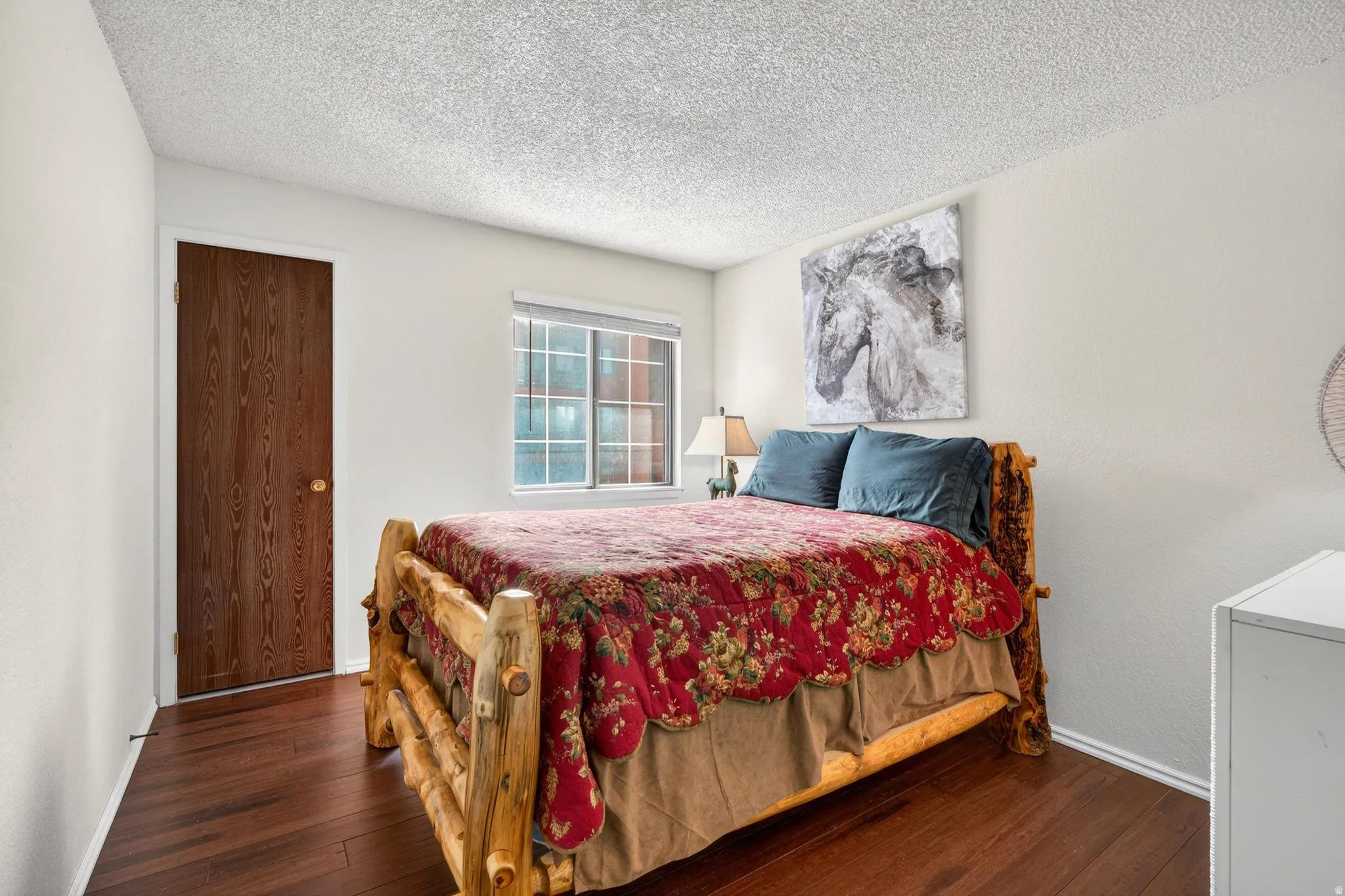 Bedroom featuring dark wood-type flooring and a textured ceiling