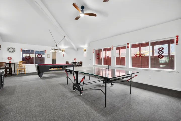 Recreation room with billiards table, lofted ceiling with beams, and a ceiling fan