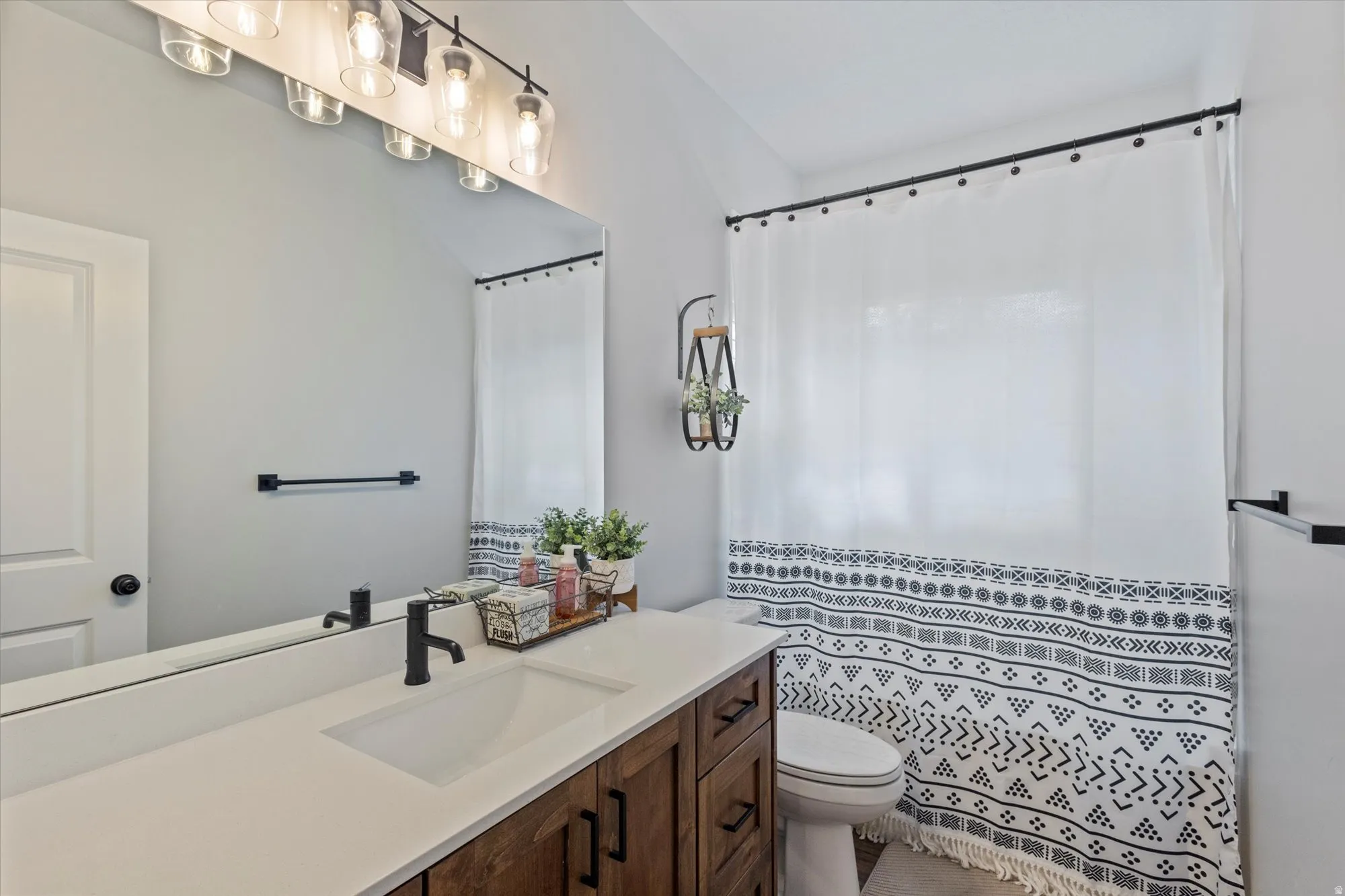 Bathroom with a shower with shower curtain and vanity