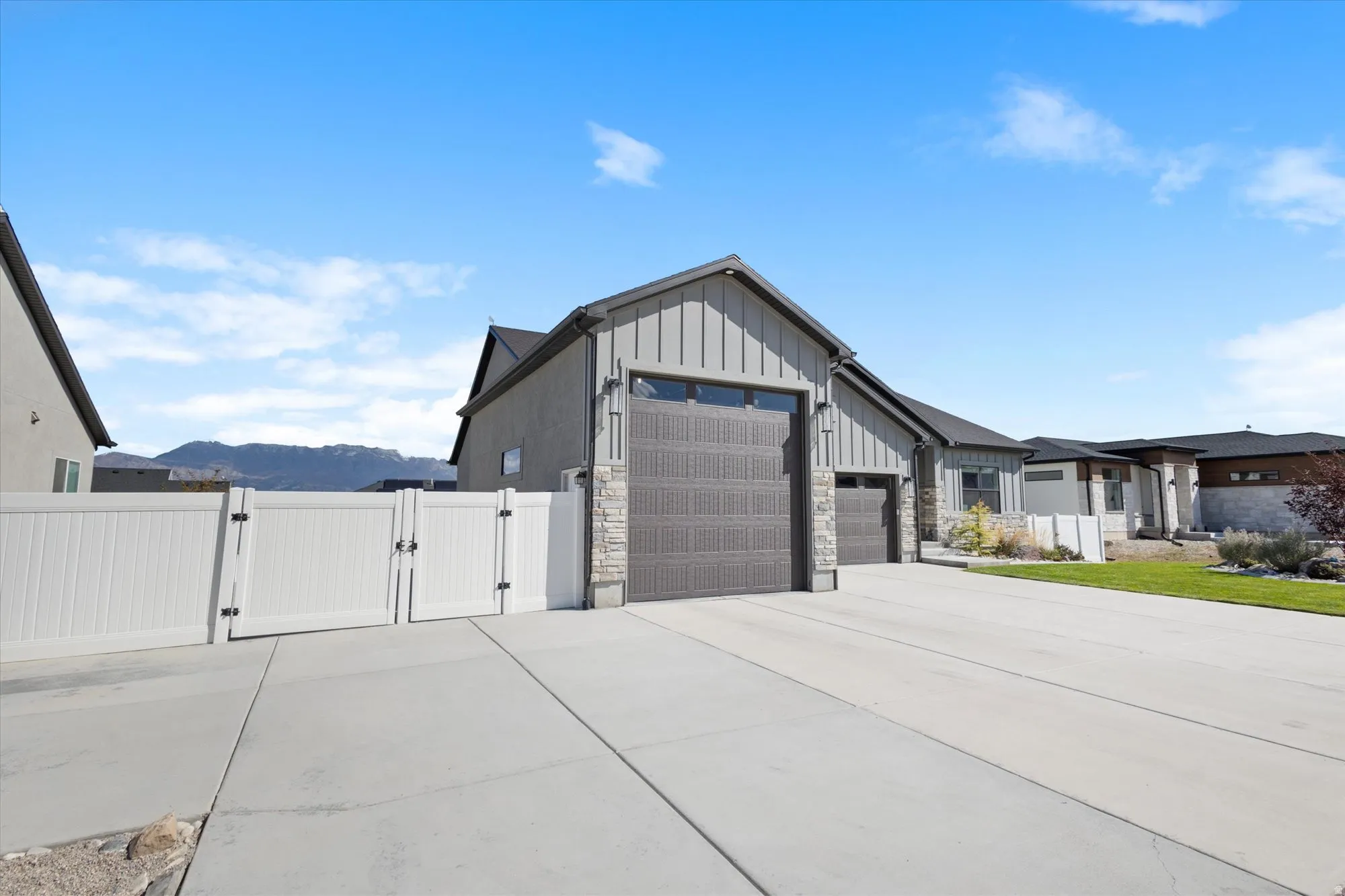 Garage featuring a gate, a mountain view, and concrete driveway