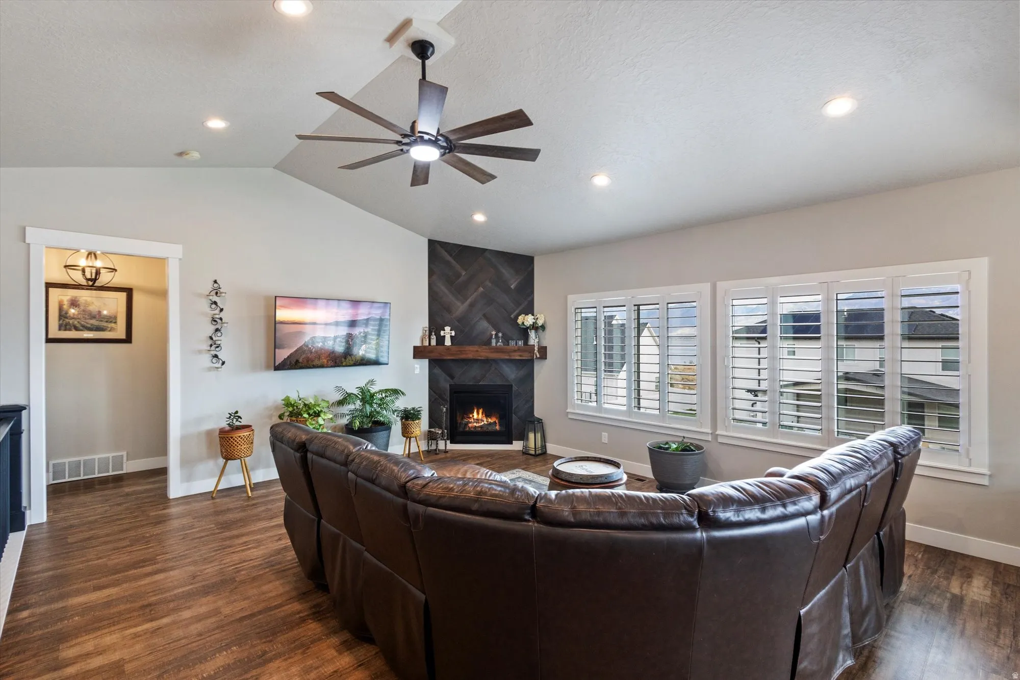 Living area featuring ceiling fan, a large fireplace, dark wood-type flooring, and recessed lighting