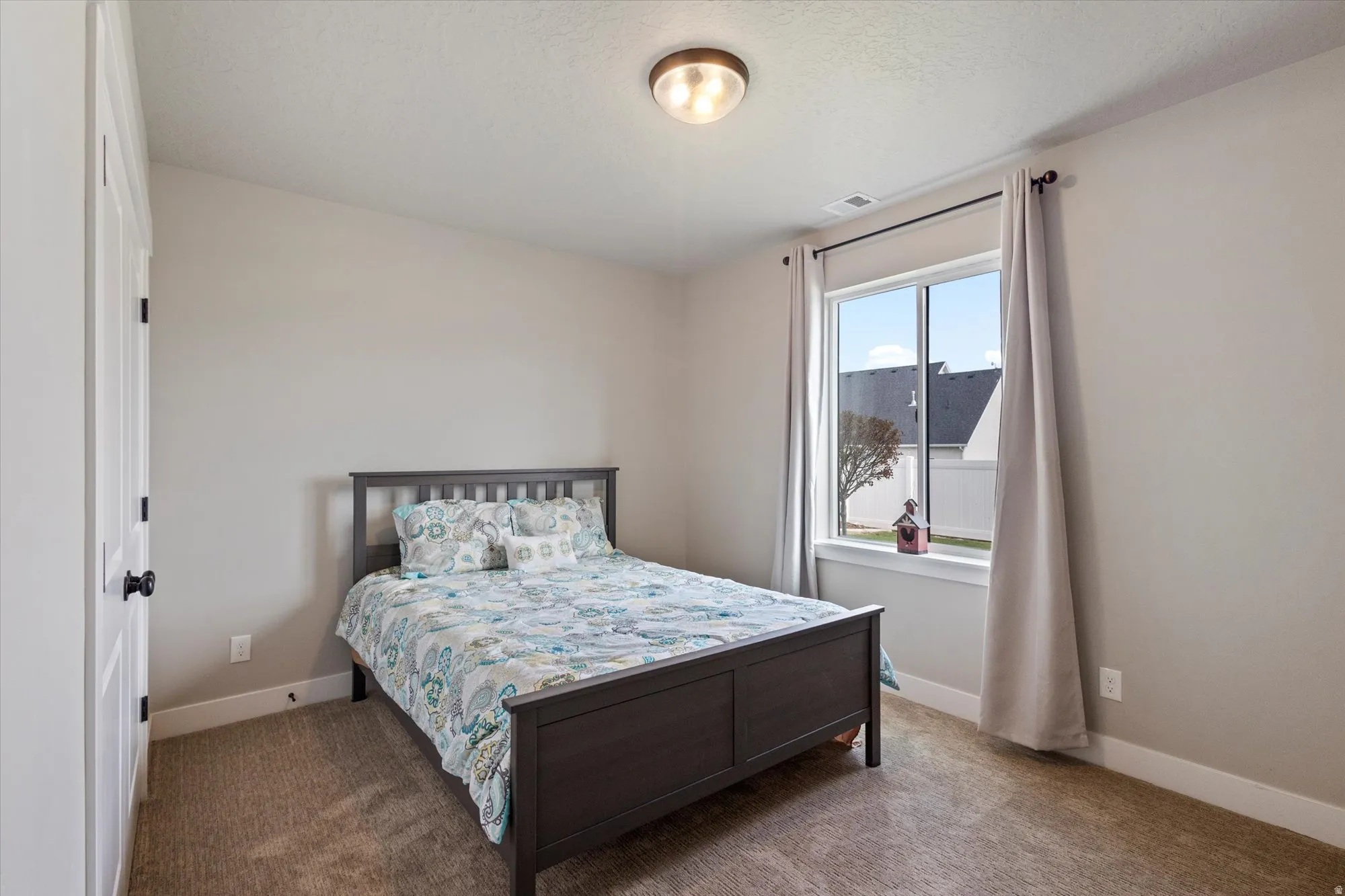 Bedroom with carpet and a textured ceiling