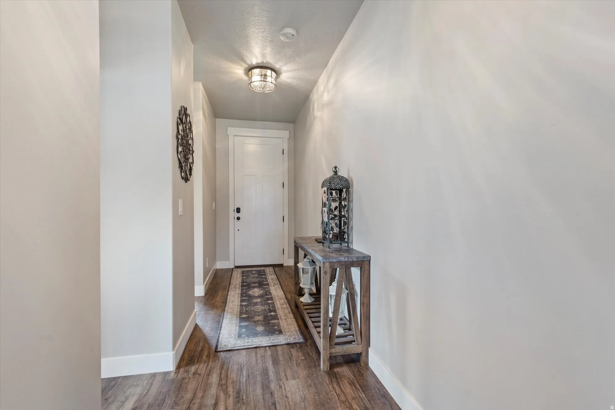 Hallway featuring baseboards and dark wood-style flooring