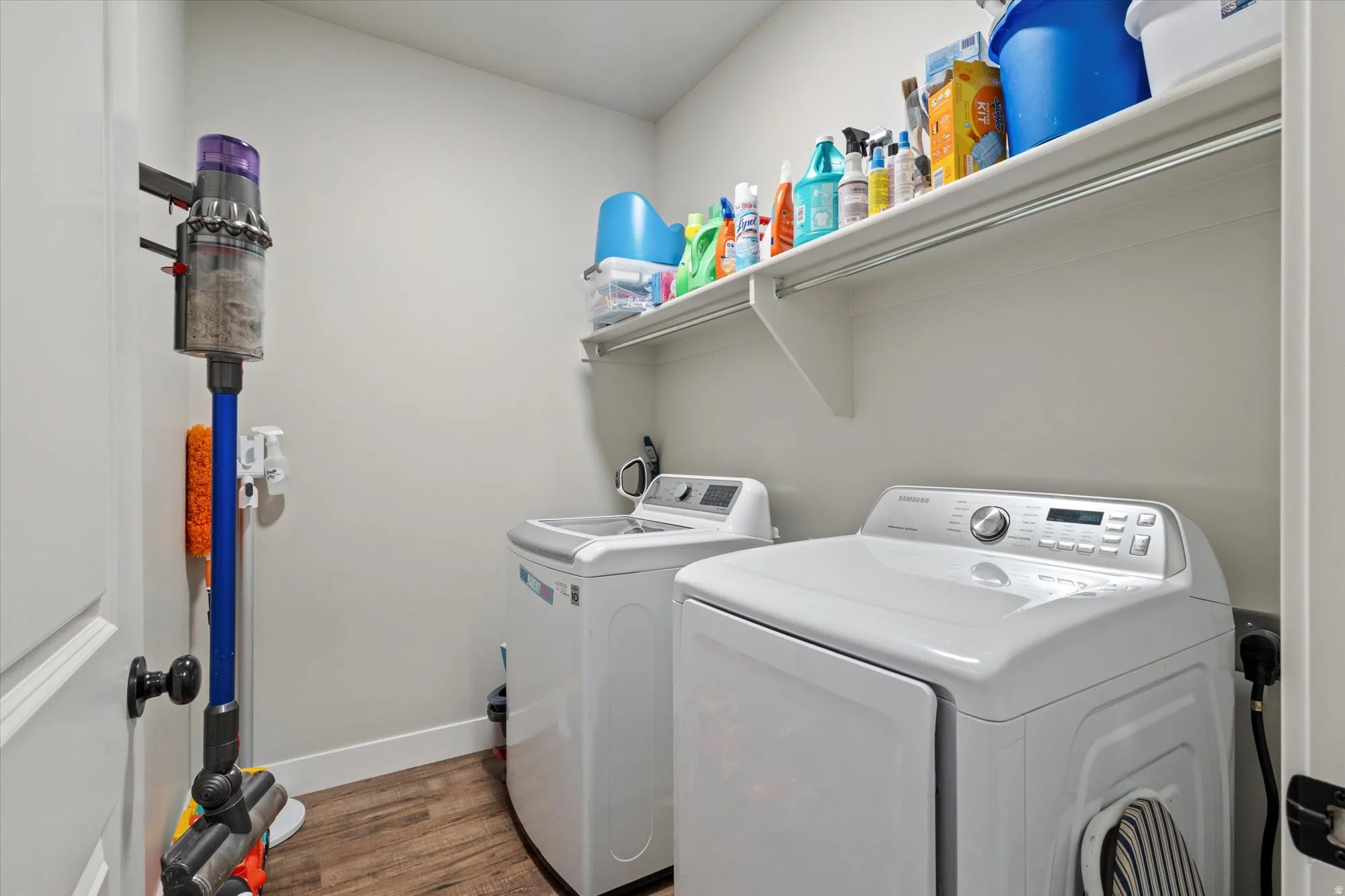 Laundry room featuring dark wood-type flooring and washer and clothes dryer