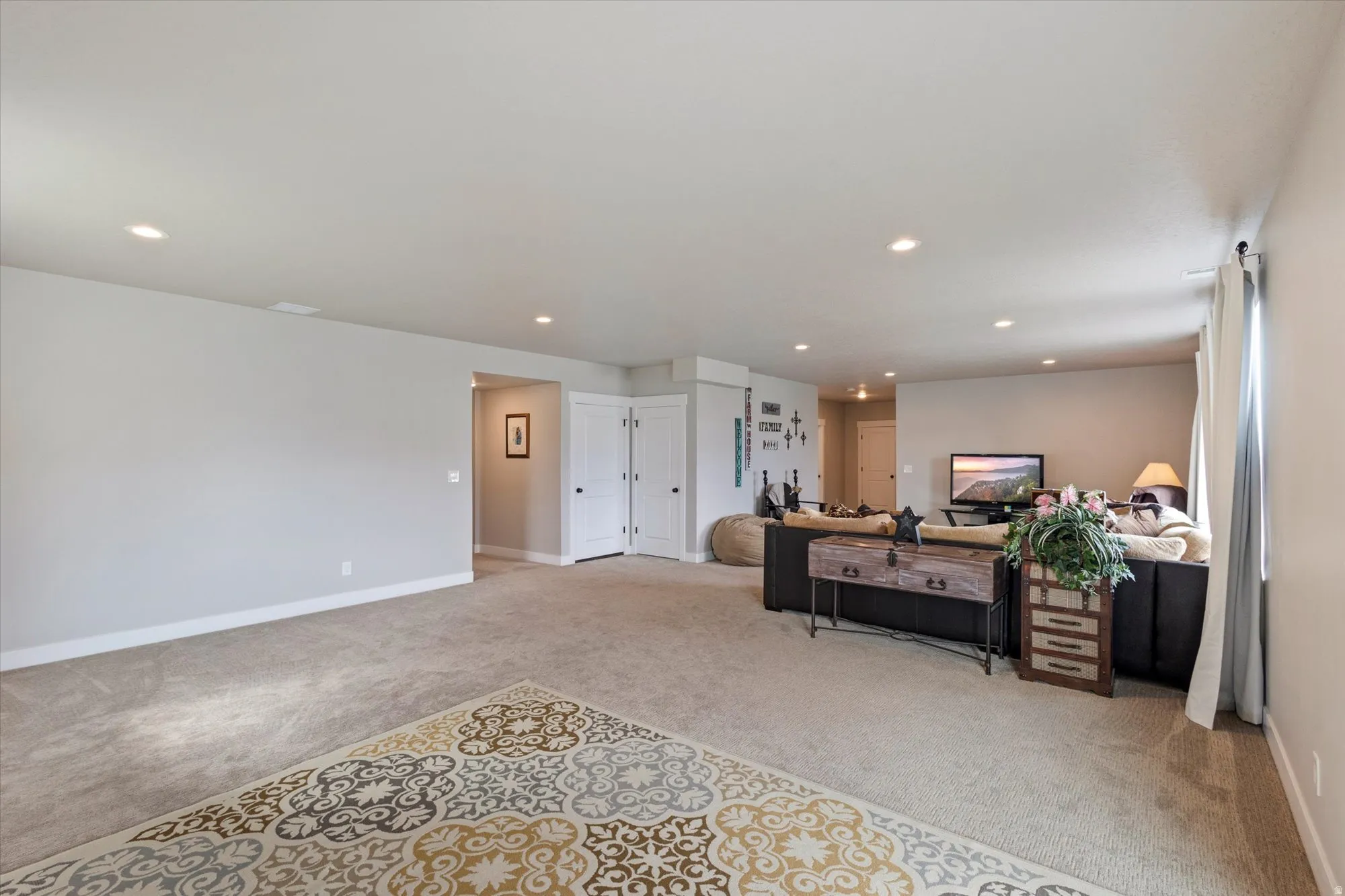 Living area featuring light colored carpet and recessed lighting