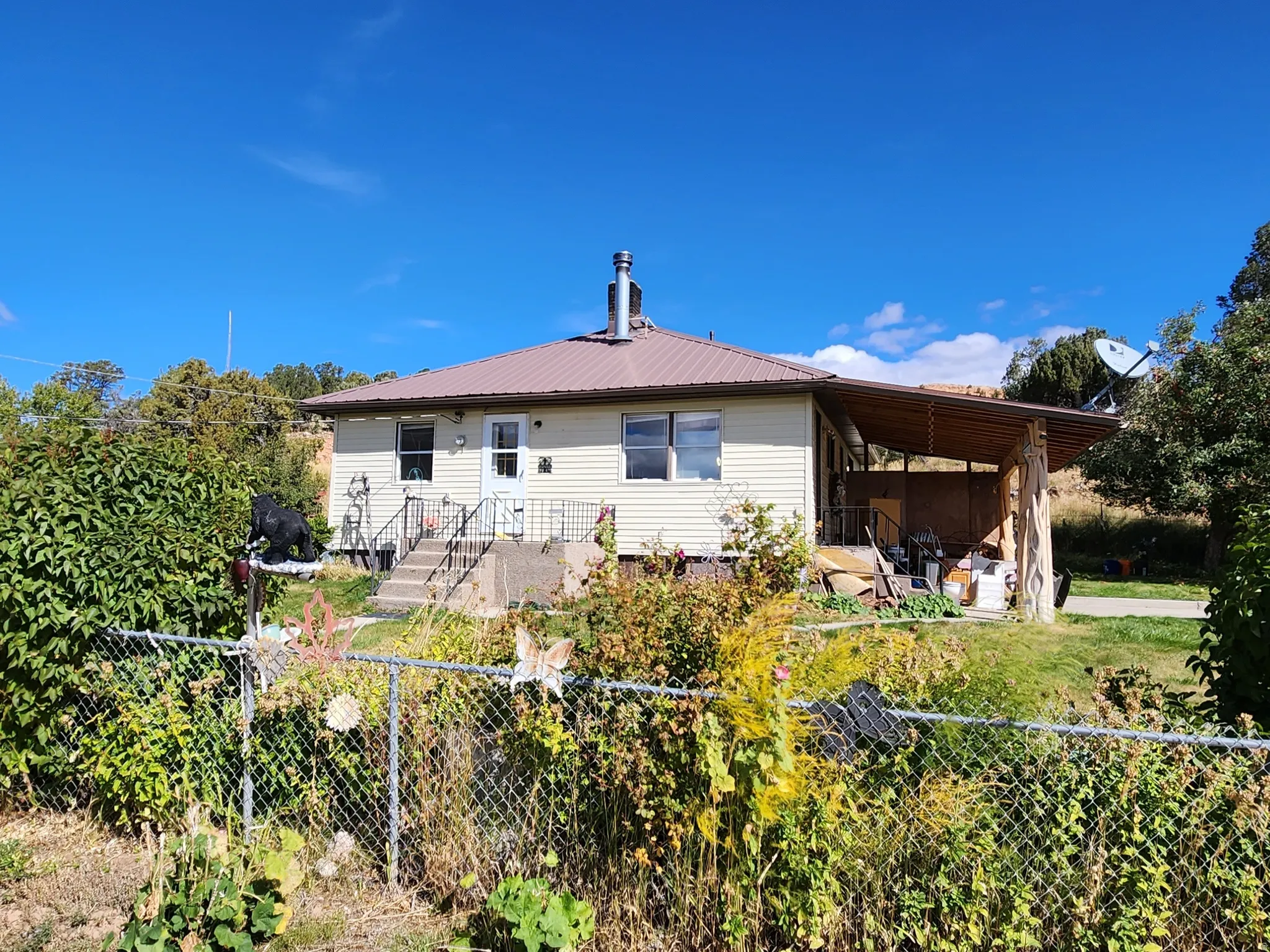 Back of house with a fenced backyard, a patio area, and a metal roof