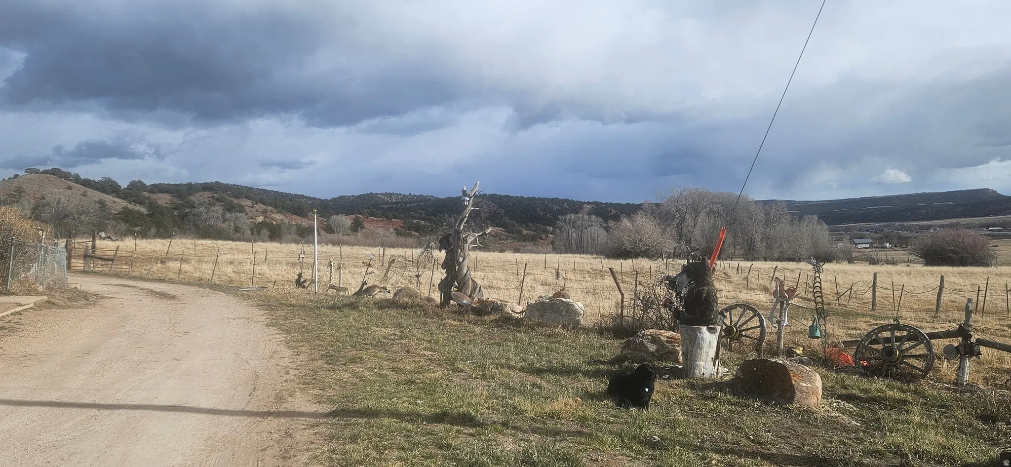 View of dirt / gravel road featuring a view of countryside and a mountain view