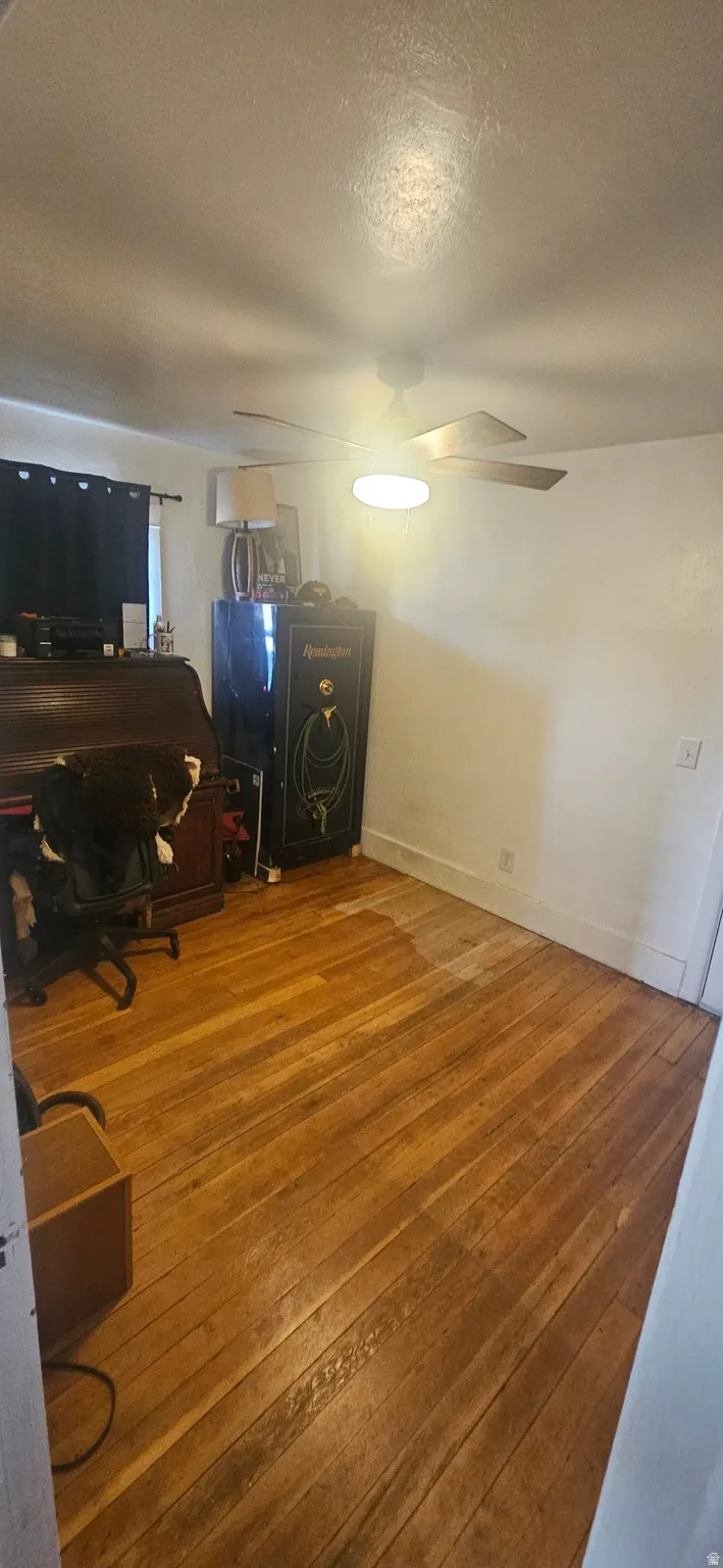 Office area with wood-type flooring, a textured ceiling, and a ceiling fan