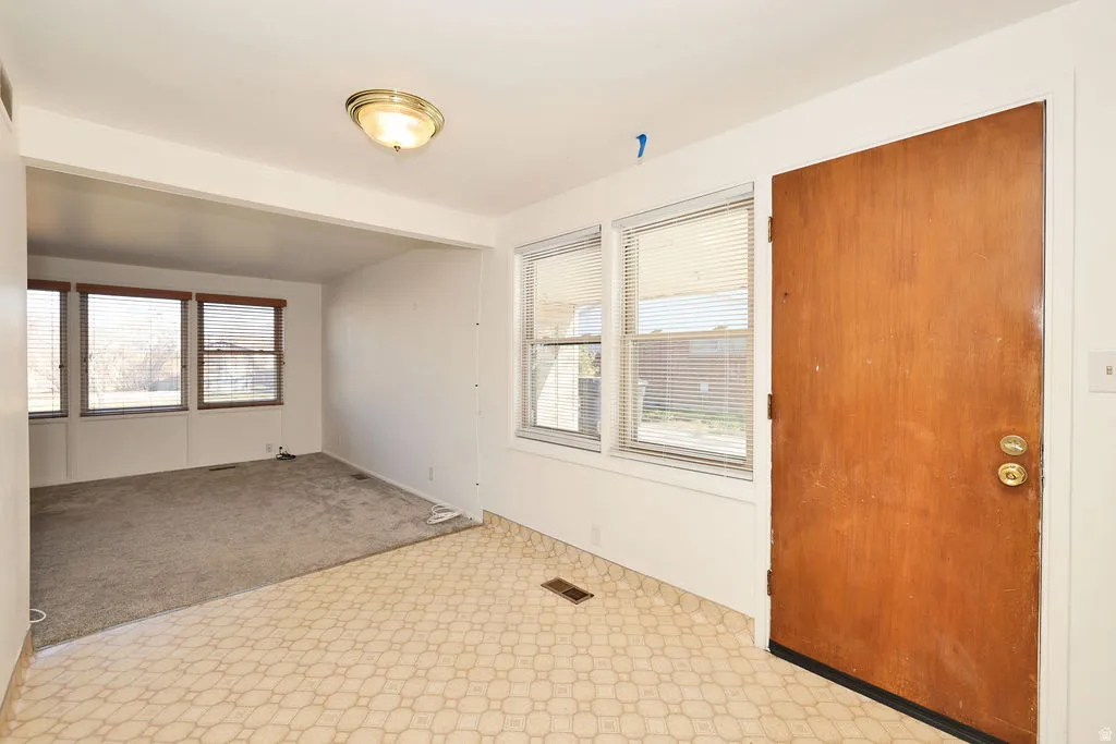 Unfurnished room featuring light carpet