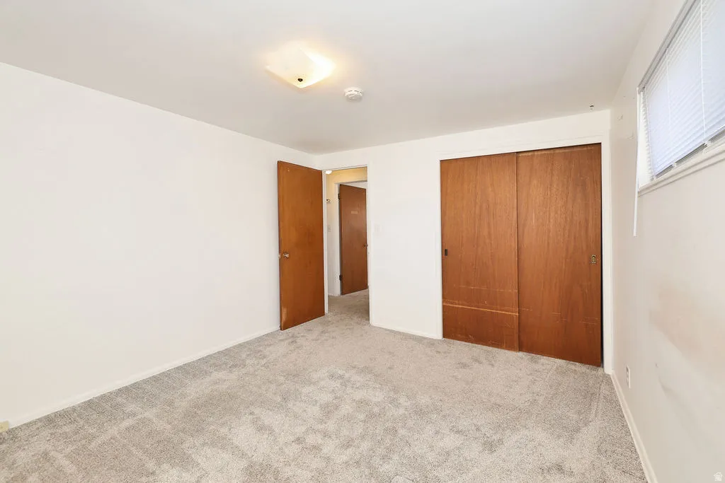 Unfurnished bedroom with carpet and a closet