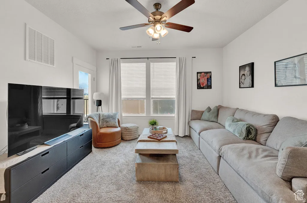 Carpeted living area with a ceiling fan