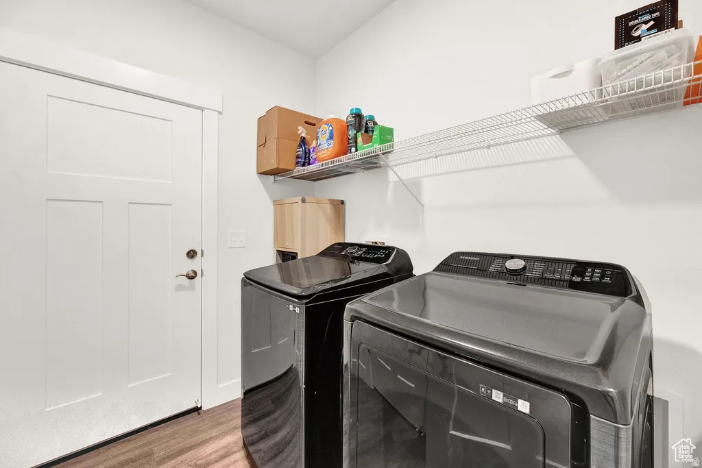 Laundry room with wood finished floors and independent washer and dryer