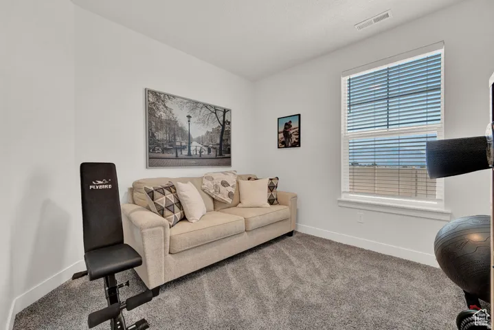 Carpeted living area featuring baseboards