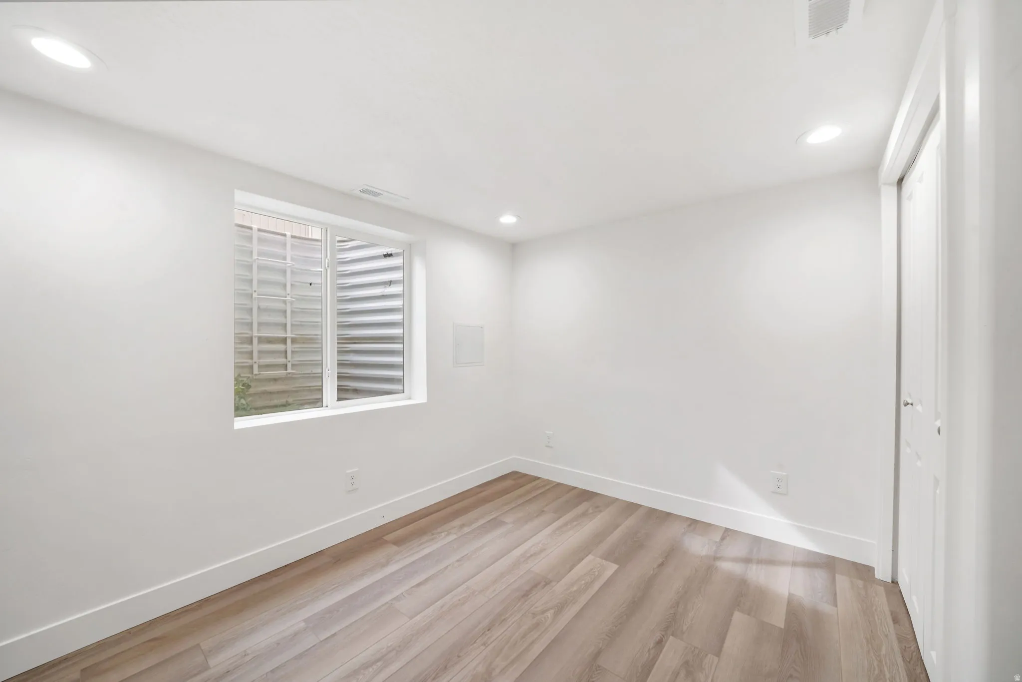 Unfurnished bedroom with a closet, light wood-style flooring, and recessed lighting