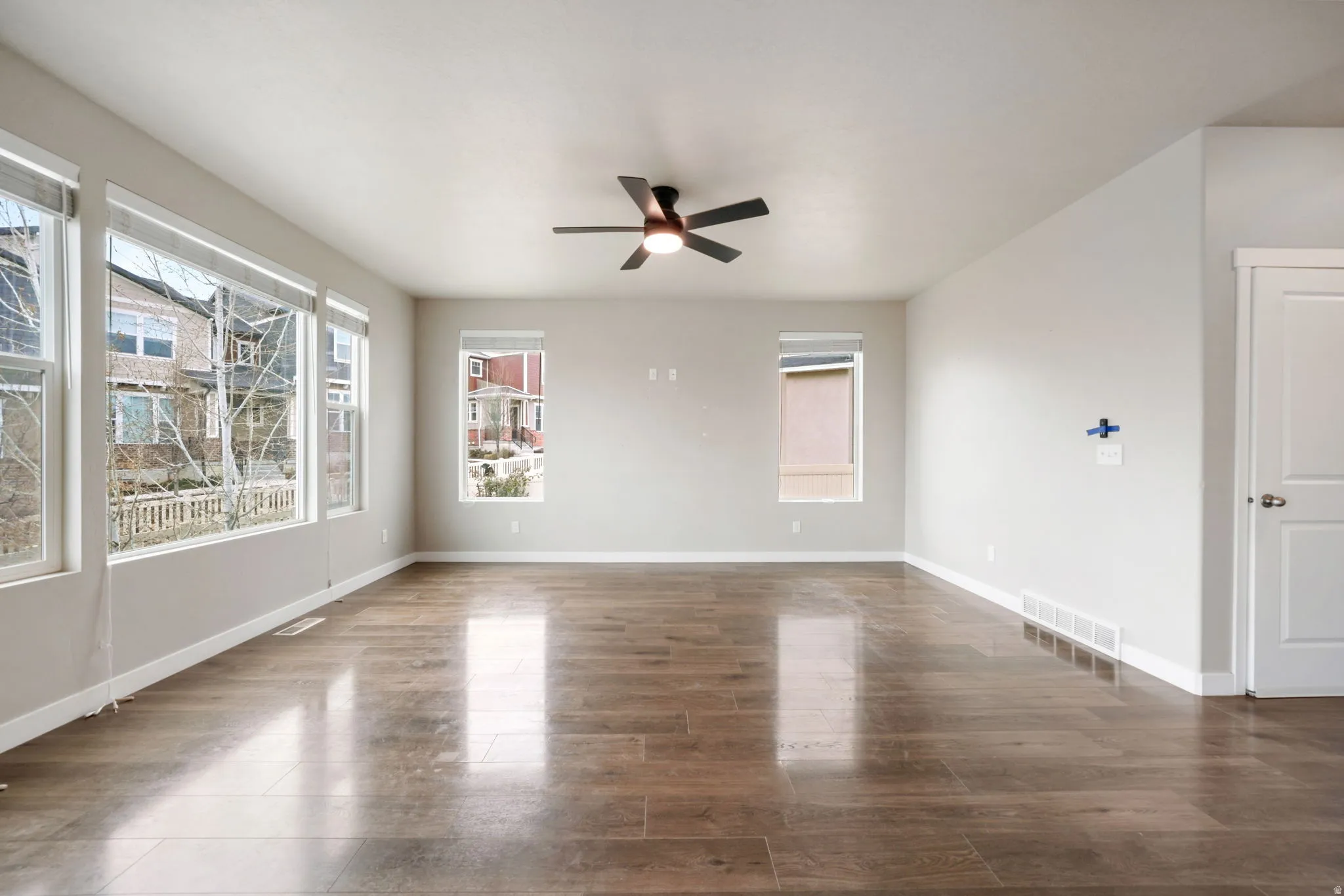 Spare room with dark wood finished floors and a ceiling fan