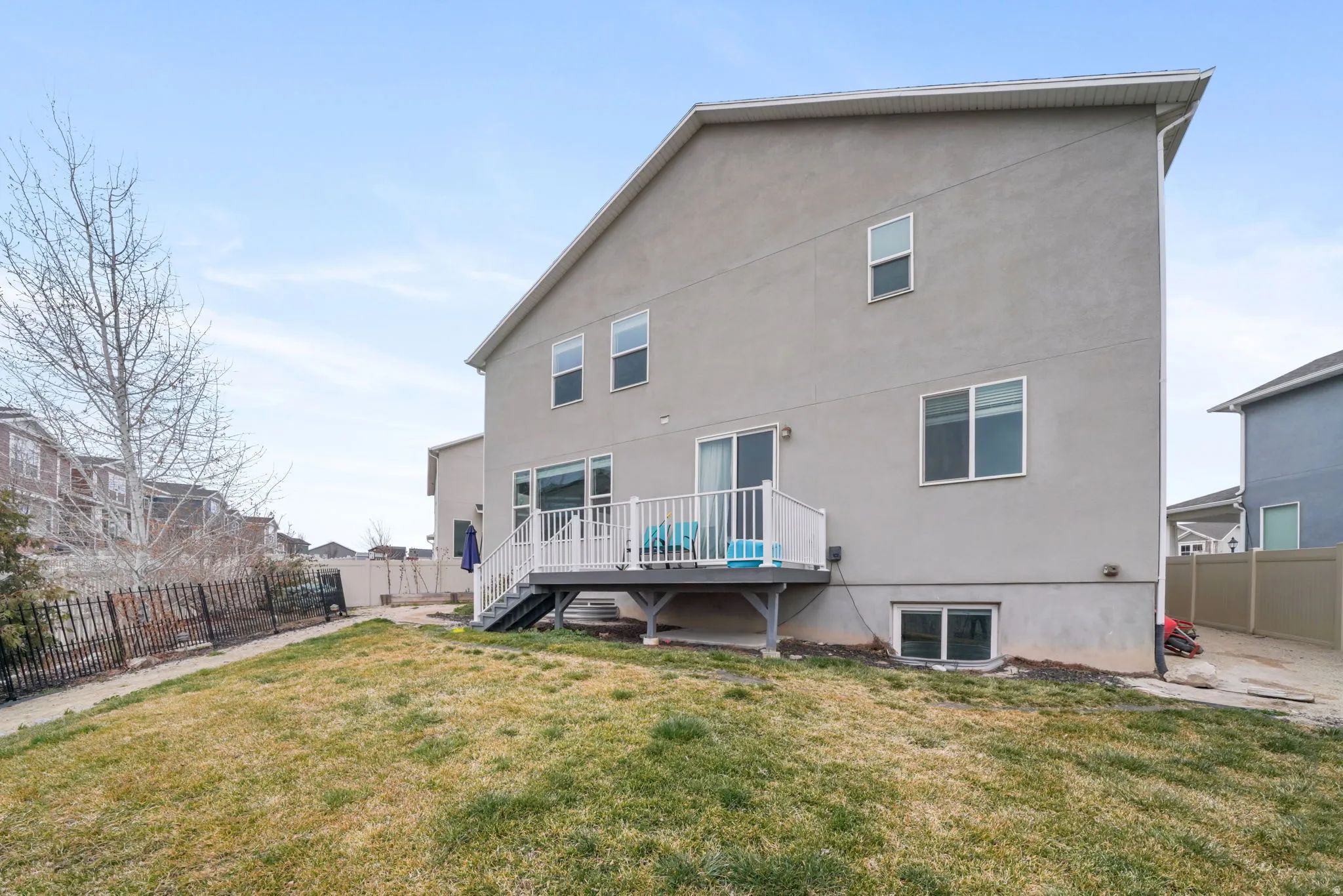 Back of house with a fenced backyard, a deck, and stucco siding