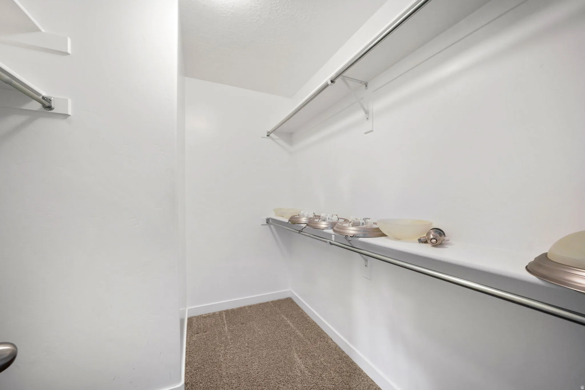 Walk in closet with light carpet