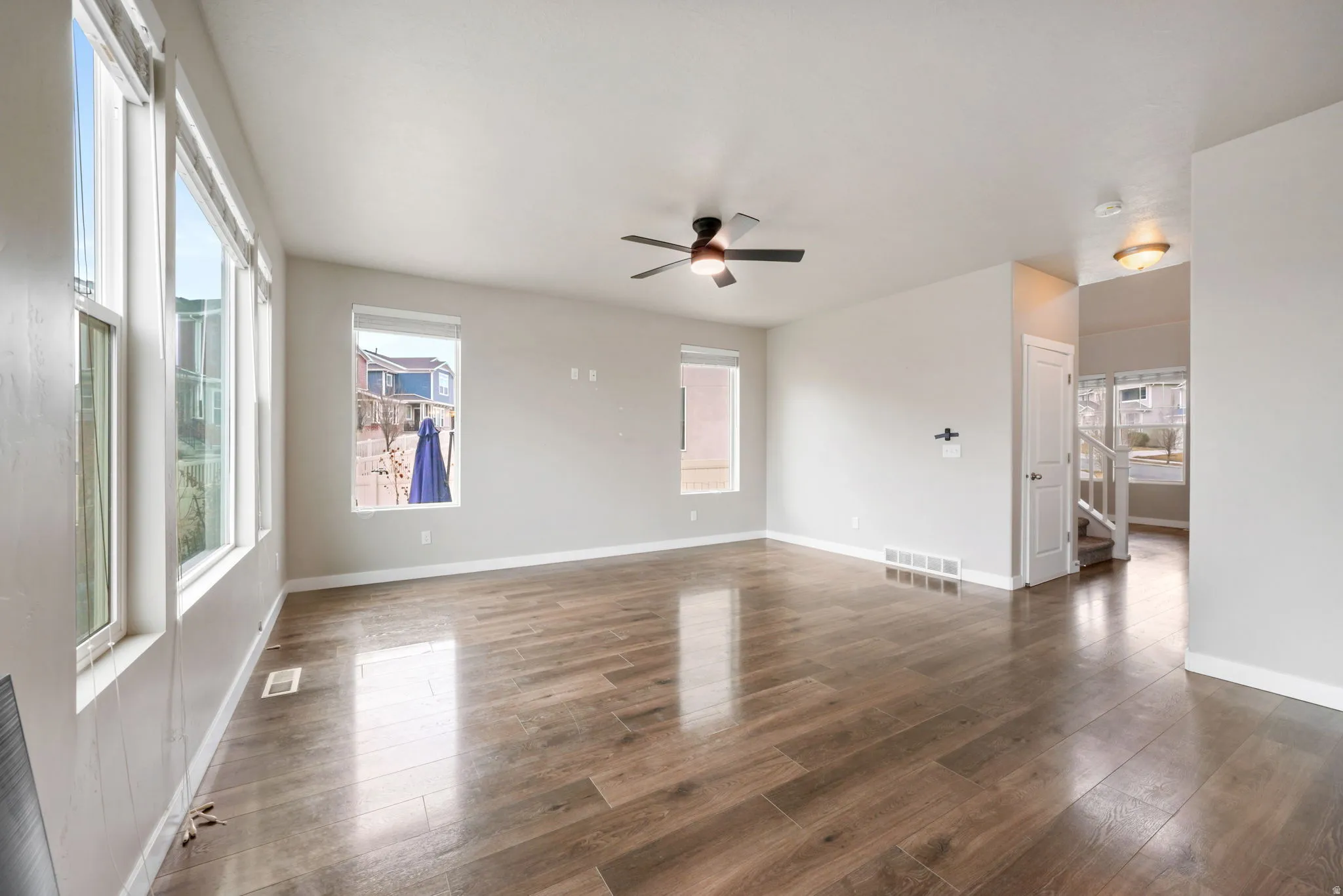 Spare room featuring a ceiling fan, hardwood / wood-style flooring, and healthy amount of natural light
