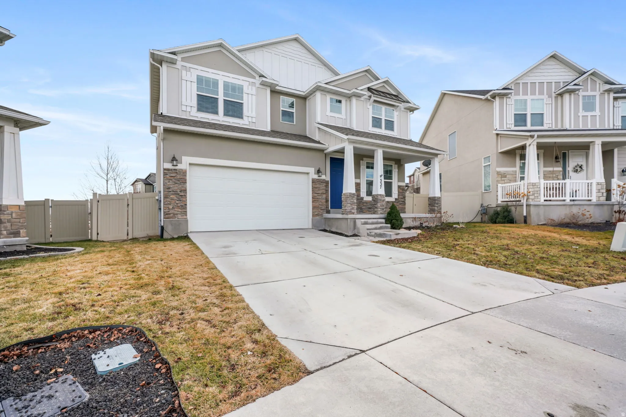Craftsman house featuring a gate, a garage, driveway, a porch, and stone siding