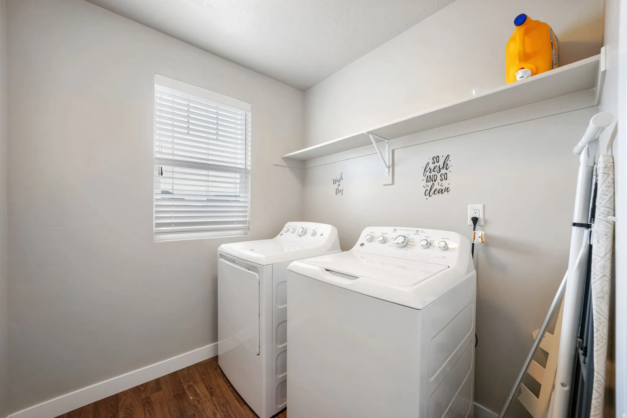 Laundry area with dark wood-style floors and separate washer and dryer