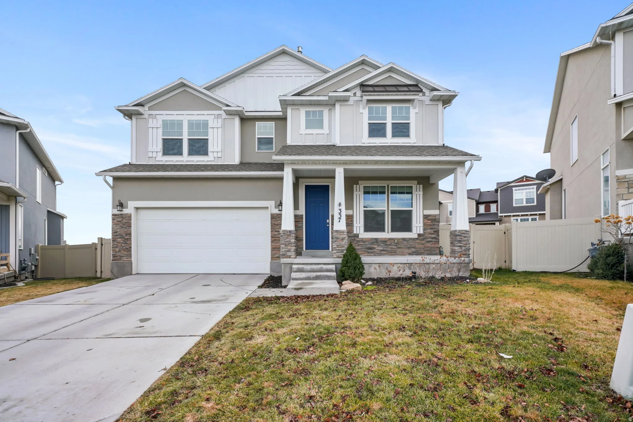 Craftsman inspired home with an attached garage, covered porch, concrete driveway, stone siding, and board and batten siding