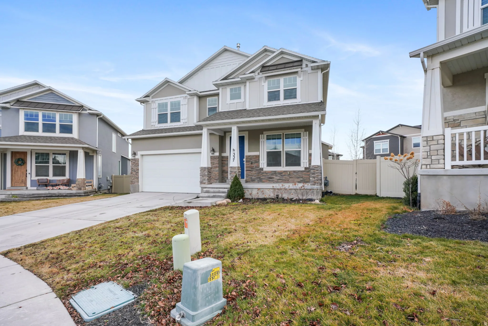 Craftsman house featuring a gate, a garage, driveway, a porch, and stone siding