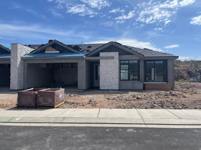 View of front of home featuring stucco siding and stone siding