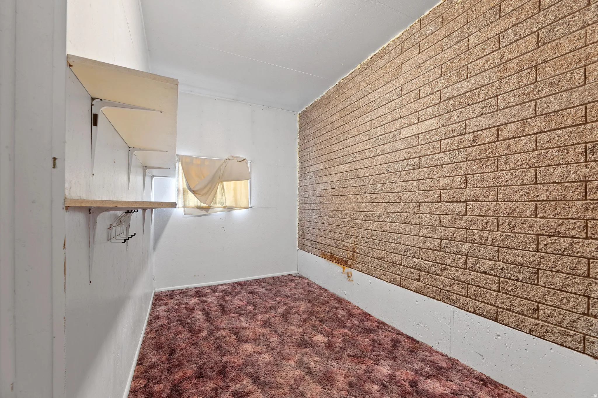 Empty room with dark carpet and an accent wall