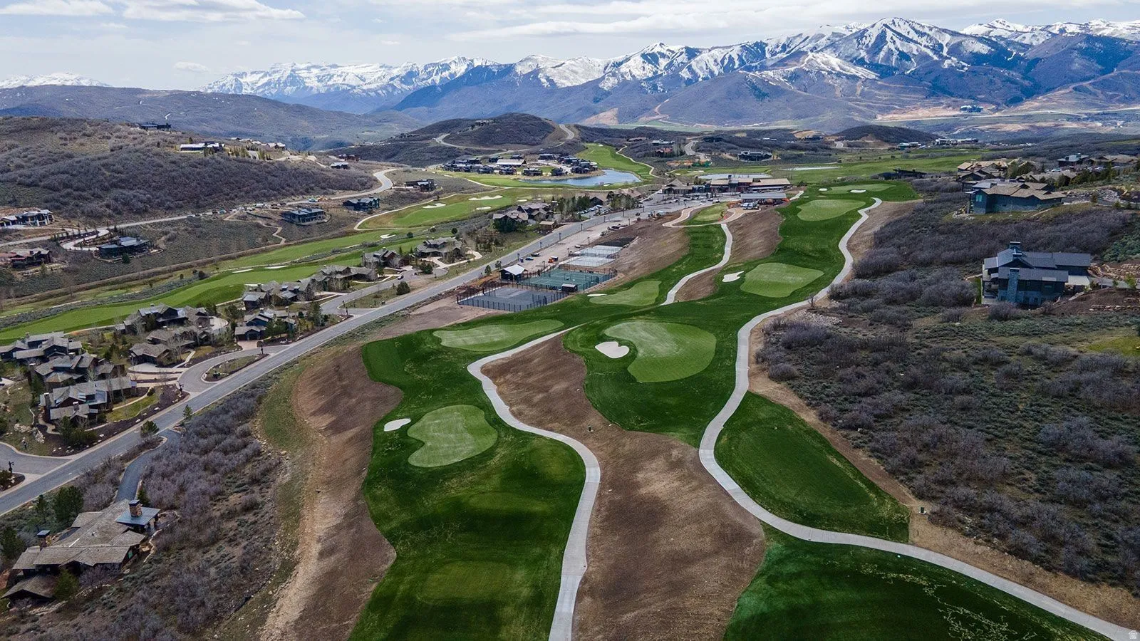 Aerial view of residential area with a golf course and a mountainous background