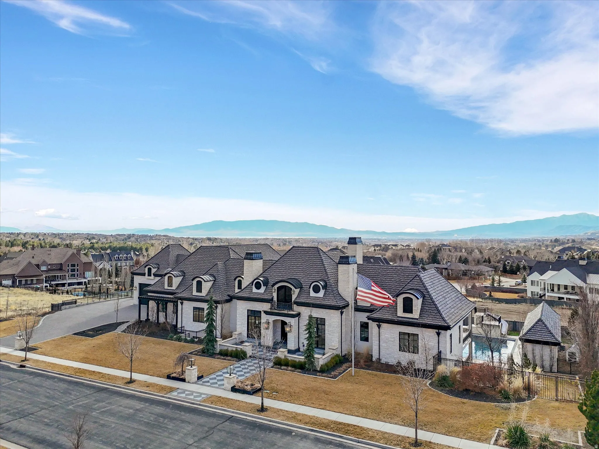 French country home with a residential view, a chimney, and stone siding
