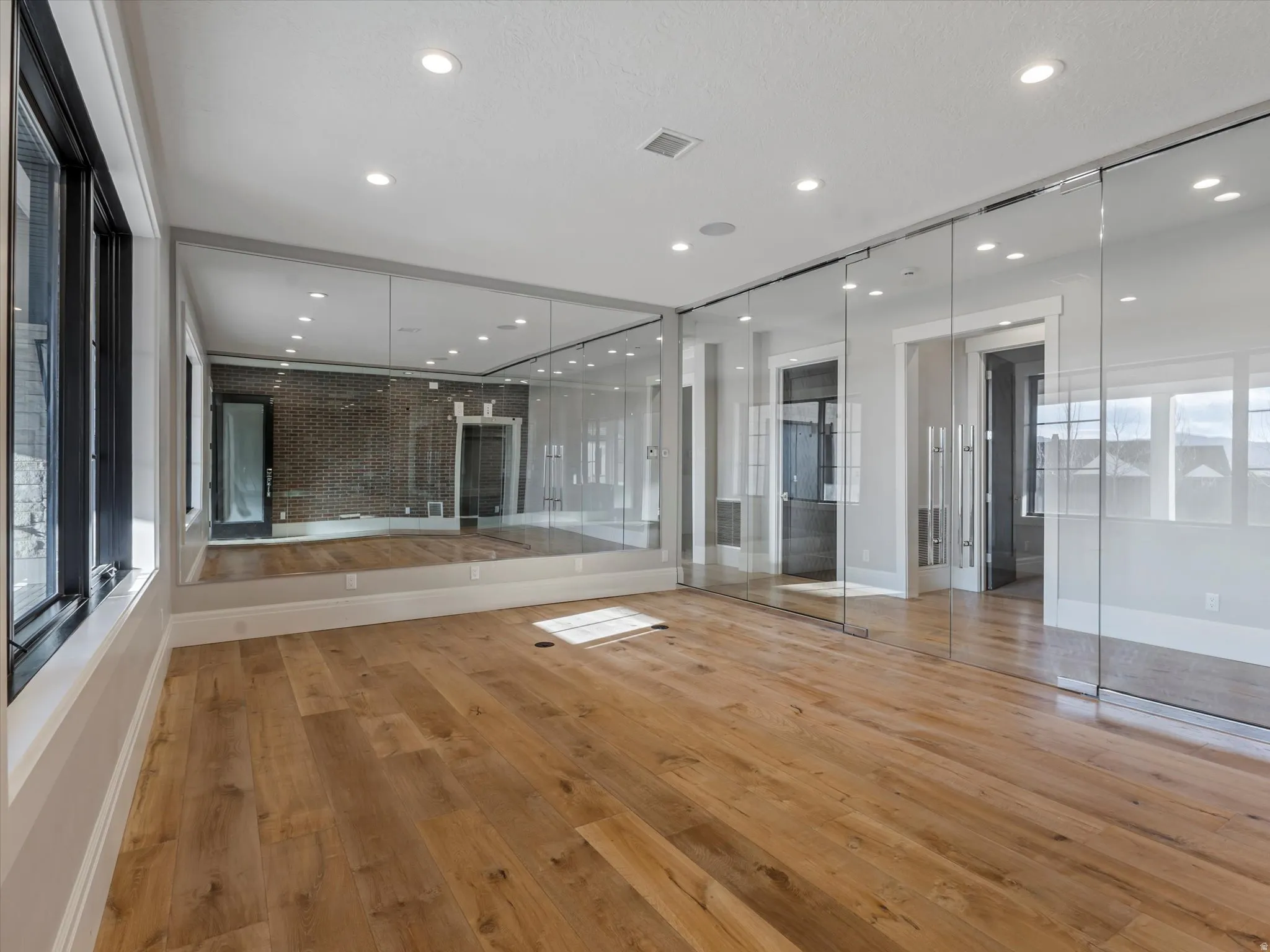 Fitness/dance space with light wood-style flooring and recessed lighting