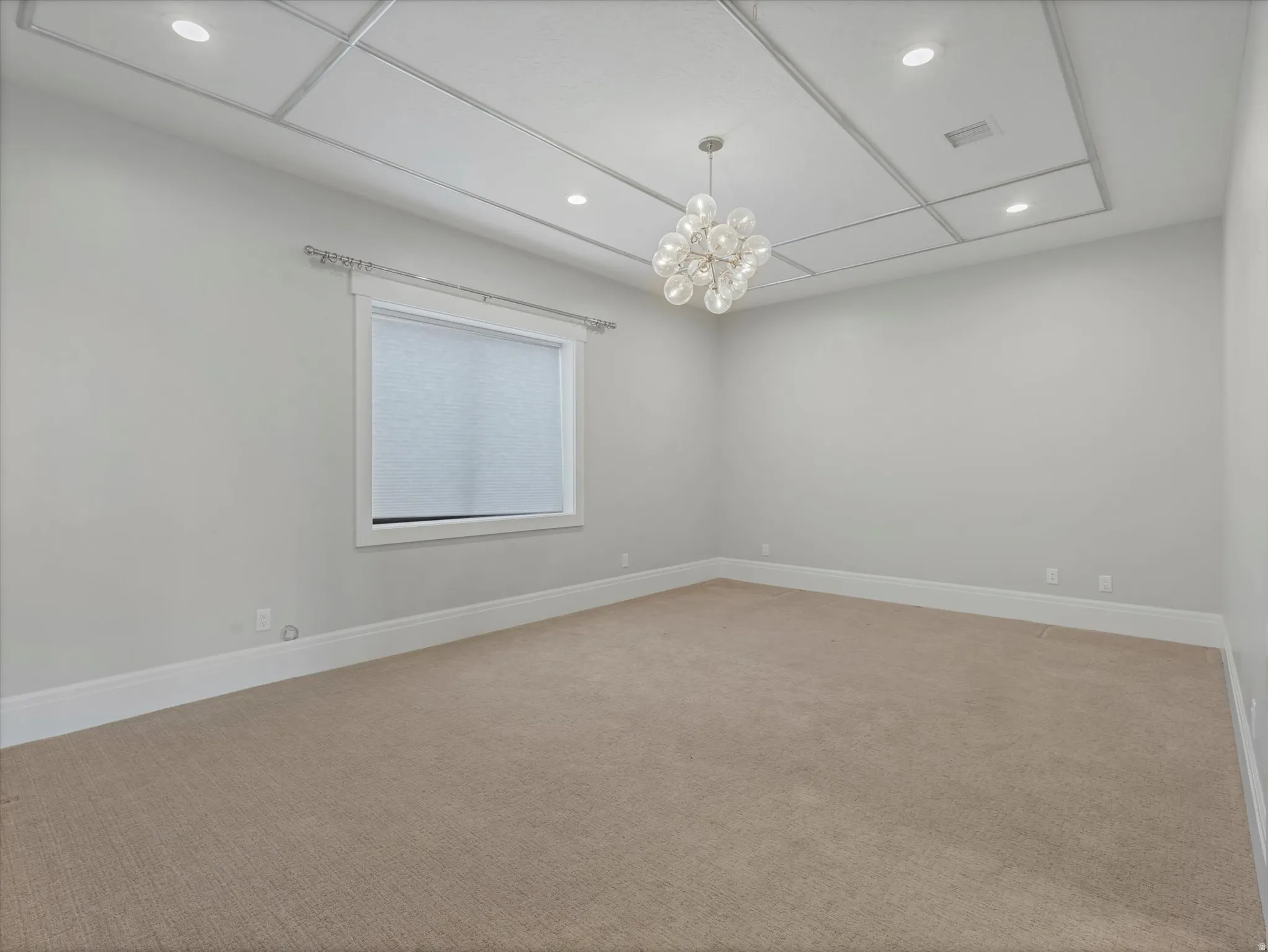 Bedroom featuring light carpet and a chandelier