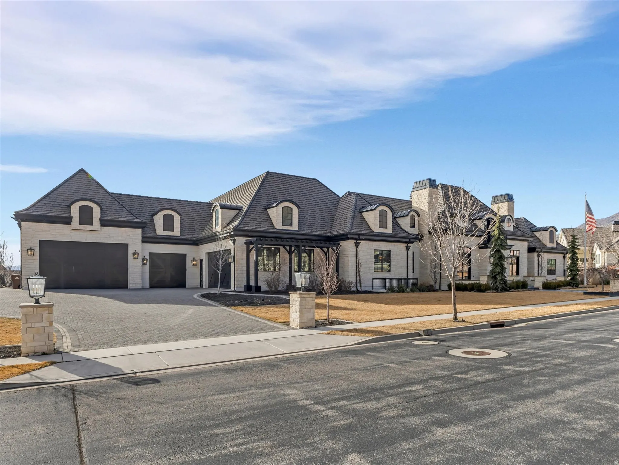 French provincial home with decorative driveway and a garage