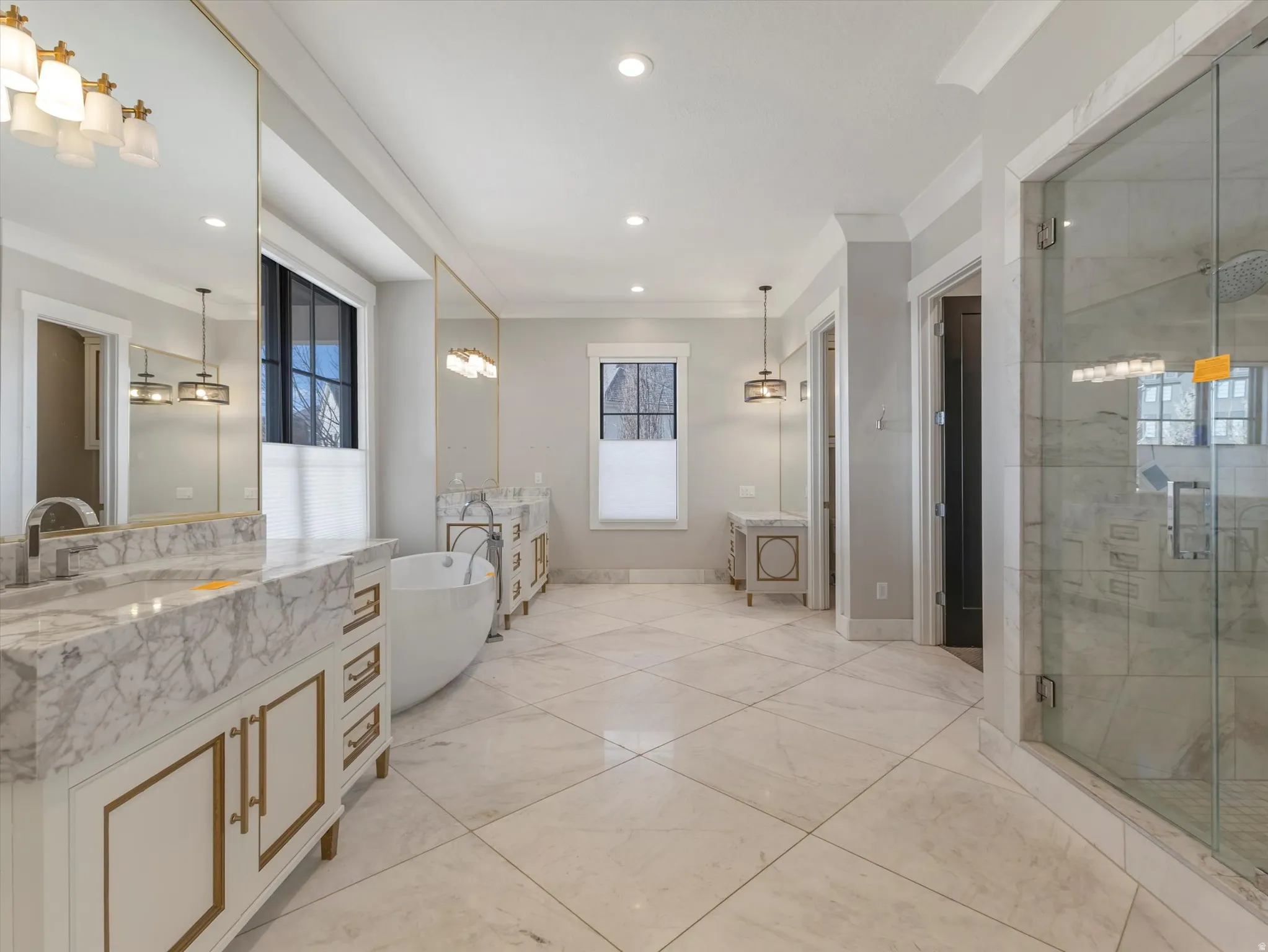 Full bathroom with a shower stall, two vanities, a soaking tub, recessed lighting, and ornamental molding
