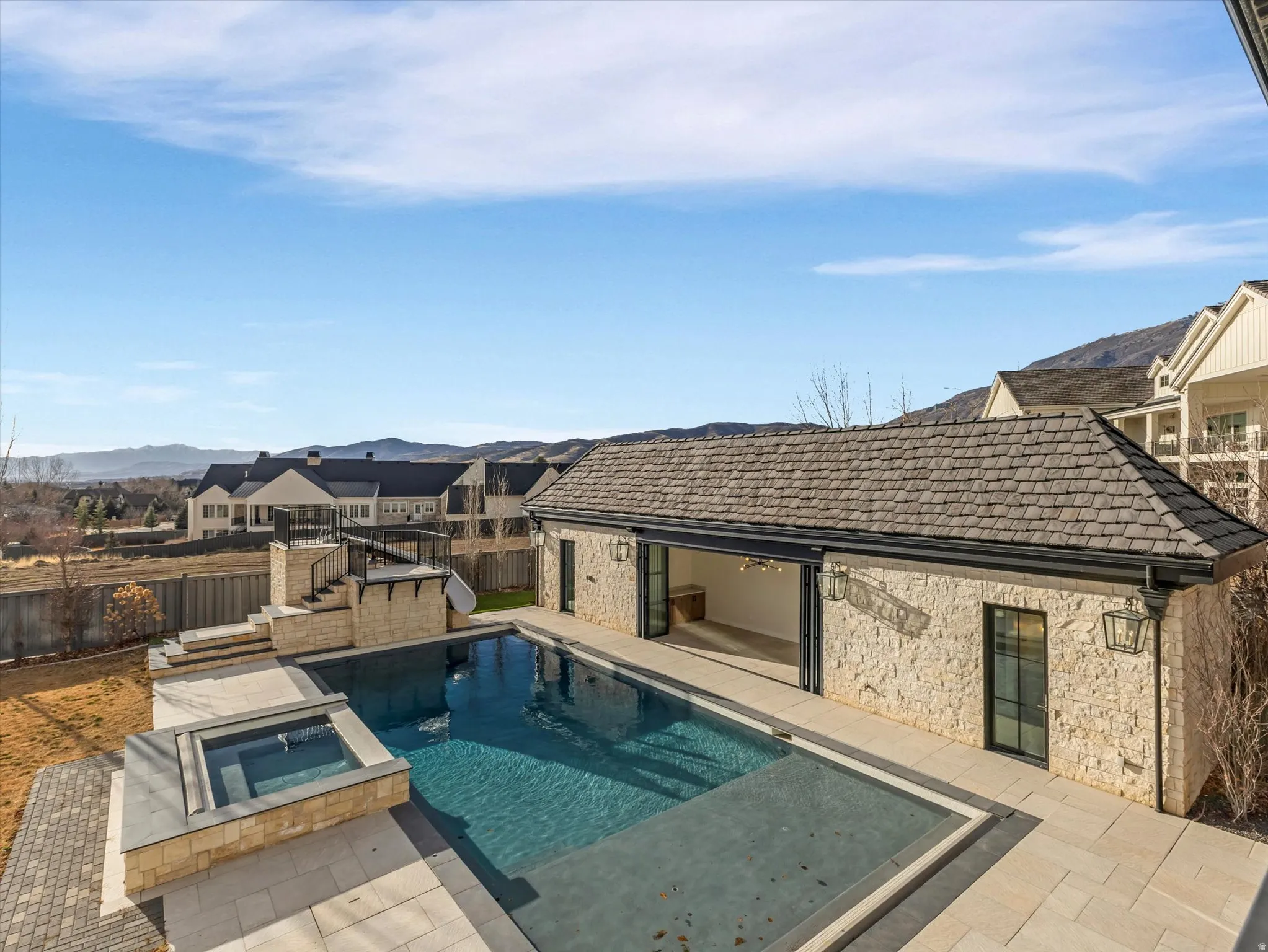 Primary bedroom private patio view of pool / spa featuring a patio, a fenced backyard, and a residential view