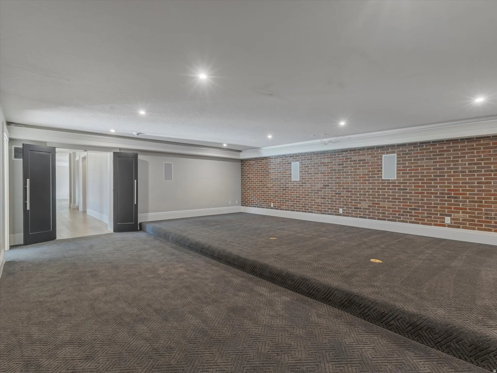 Theatre with carpet flooring, brick wall, and recessed lighting